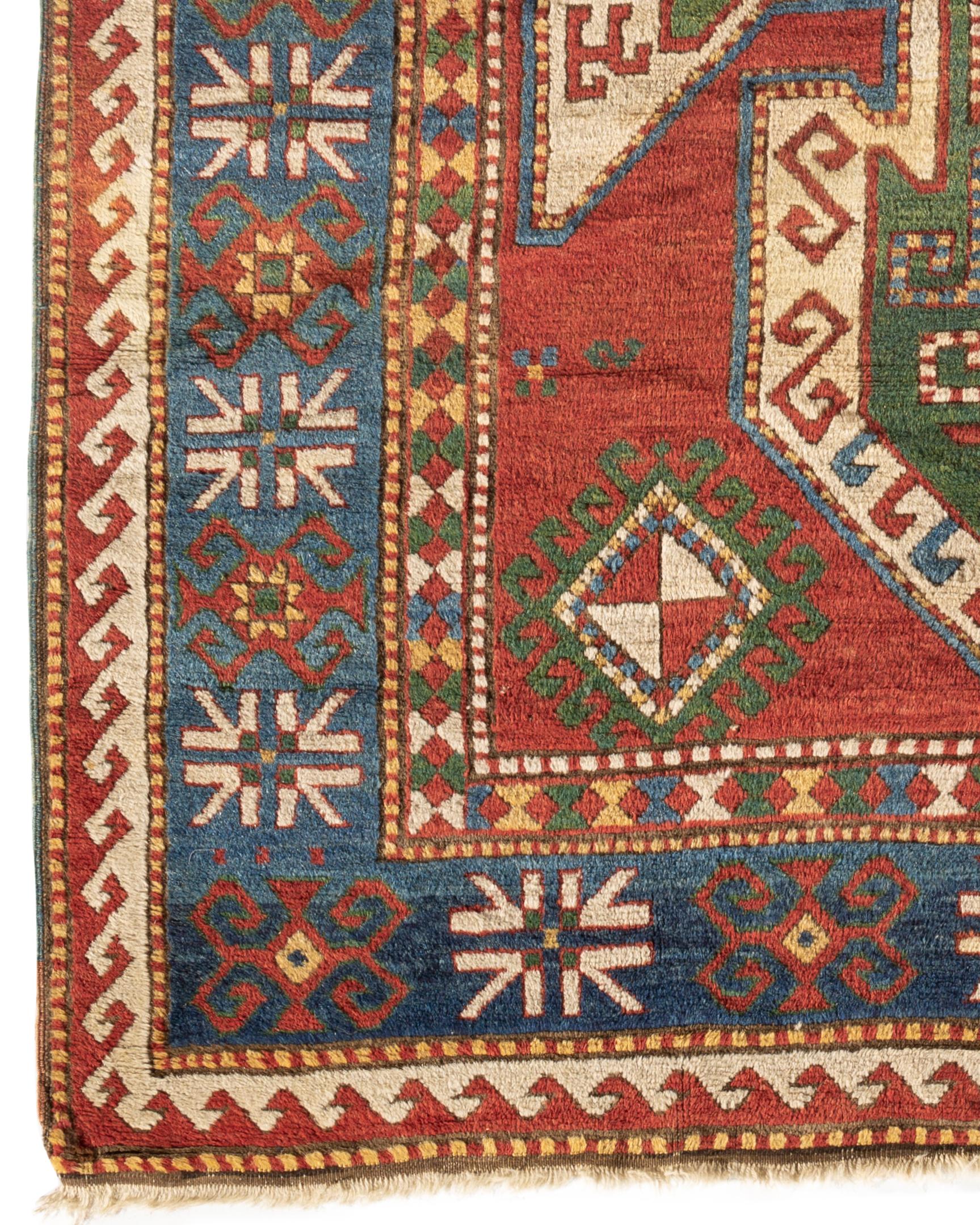 Antique Caucasian Sewan Sevan Kazak rug, circa 1880. The large shield medallion typical on Sewan Kazaks in greens and ivory on an almost madder red field. The main soft blue border with star motifs itself enclose within guard borders to create a