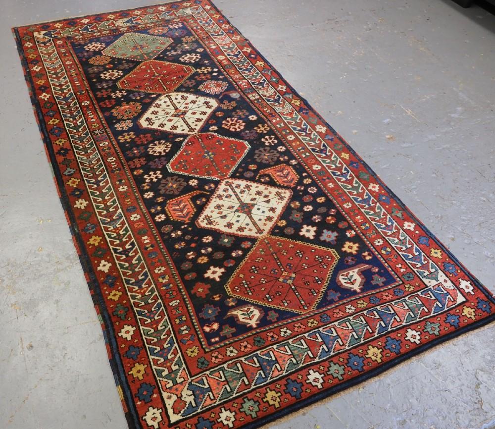 Antiker kaukasischer Schirwan-Khila-Teppich aus der Region Baku im Ostkaukasus
CIRCA 1900

Ein gutes Beispiel für einen langen Khila-Teppich mit sechs Medaillons auf einem dunkel indigoblauen Grund. Die Medaillons haben das klassische