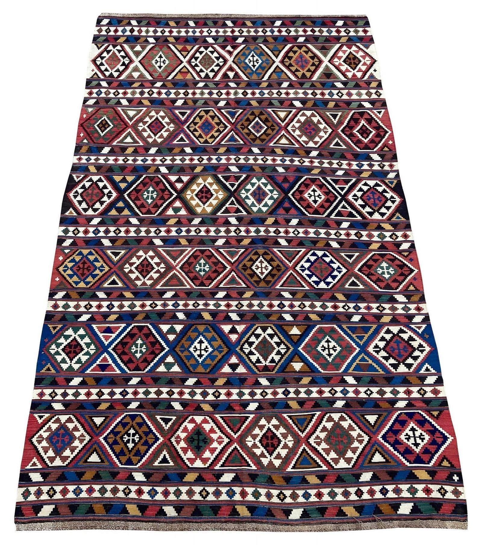 A stunning antique kilim, hand woven circa 1900 in or around Shirvan in what is now south-east Azerbaidjan. The kilim has been finely woven in a traditional banded design of hooked medallions with fabulous colours.
Size: 3.33m x 1.96m (10ft 11in x