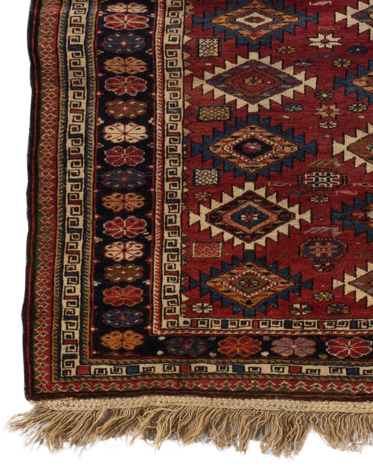 Tapis caucasien Shirvan ancien, vers 1880. Le champ est composé de losanges avec un contour ivoire et bleu entourant des têtes de fleurs dans des bordures multiples traditionnelles de Shirvan encadrant le tapis. Ces types de tapis caucasiens anciens