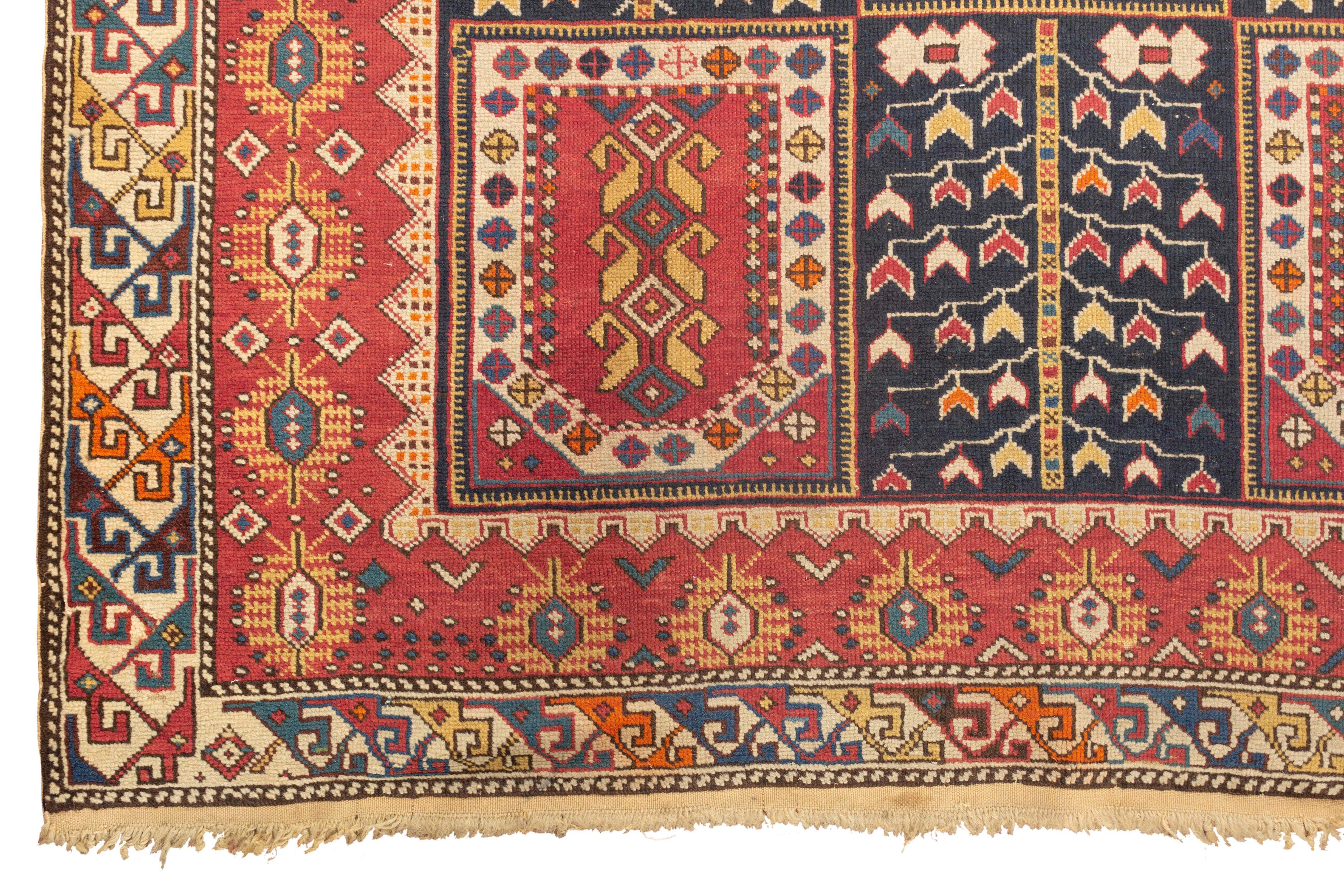 Tapis caucasien Shirvan ancien, vers 1880. Le fond bleu marine présente six boucliers avec un motif délicat qui se répète dans la bordure principale, le fond bleu marine rempli d'éléments floraux et la bordure extérieure répétant ce motif créent un
