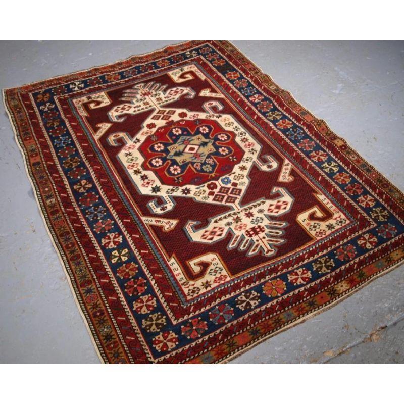 Antique South East Caucasian Shirvan rug with 'gymyl' design, often known as the dragon motif. The rug is a good example with bold design and striking contrast of colours, the ivory design stands out against the fine field lattice design in indigo