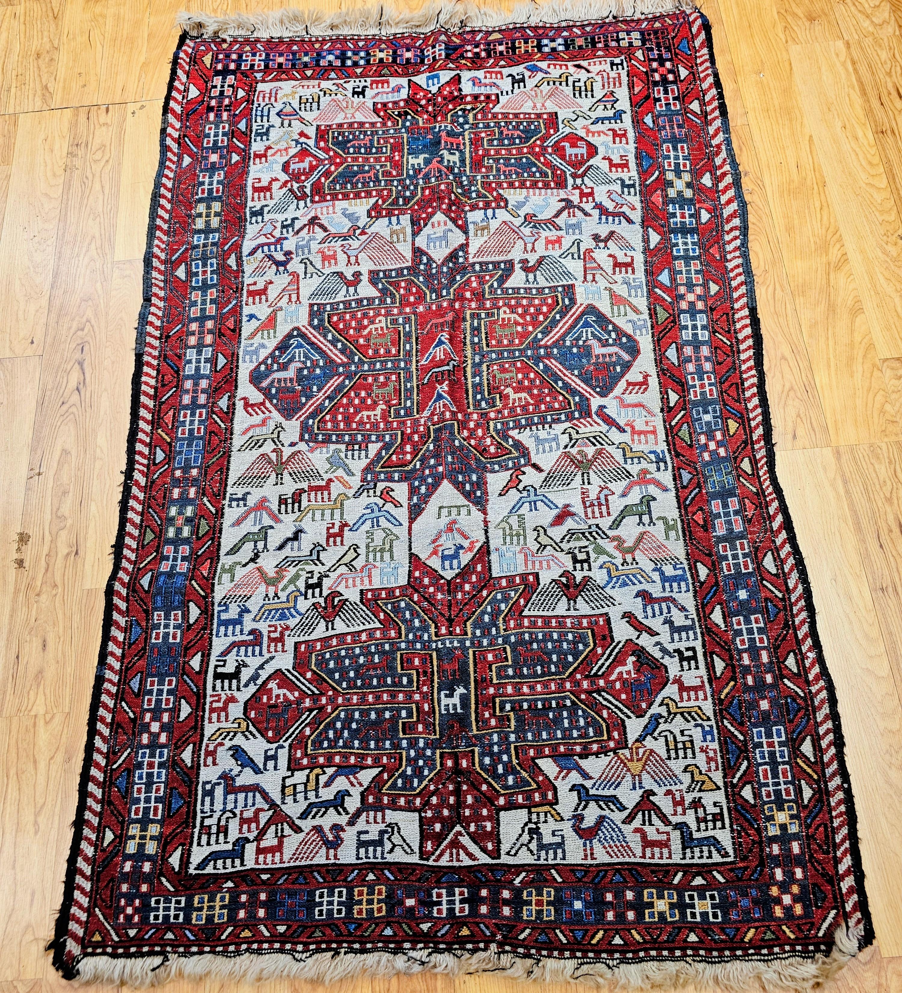 This exceptional Antique Caucasian Soumak area rug features a striking three-medallion design in rich shades of red, blue, and green set on an elegant ivory field. The field is beautifully detailed with intricate bird motifs, symbolizing protection