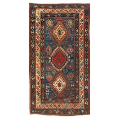 Tapis caucasien ancien tribal bleu et rouge, vers 1900-1910