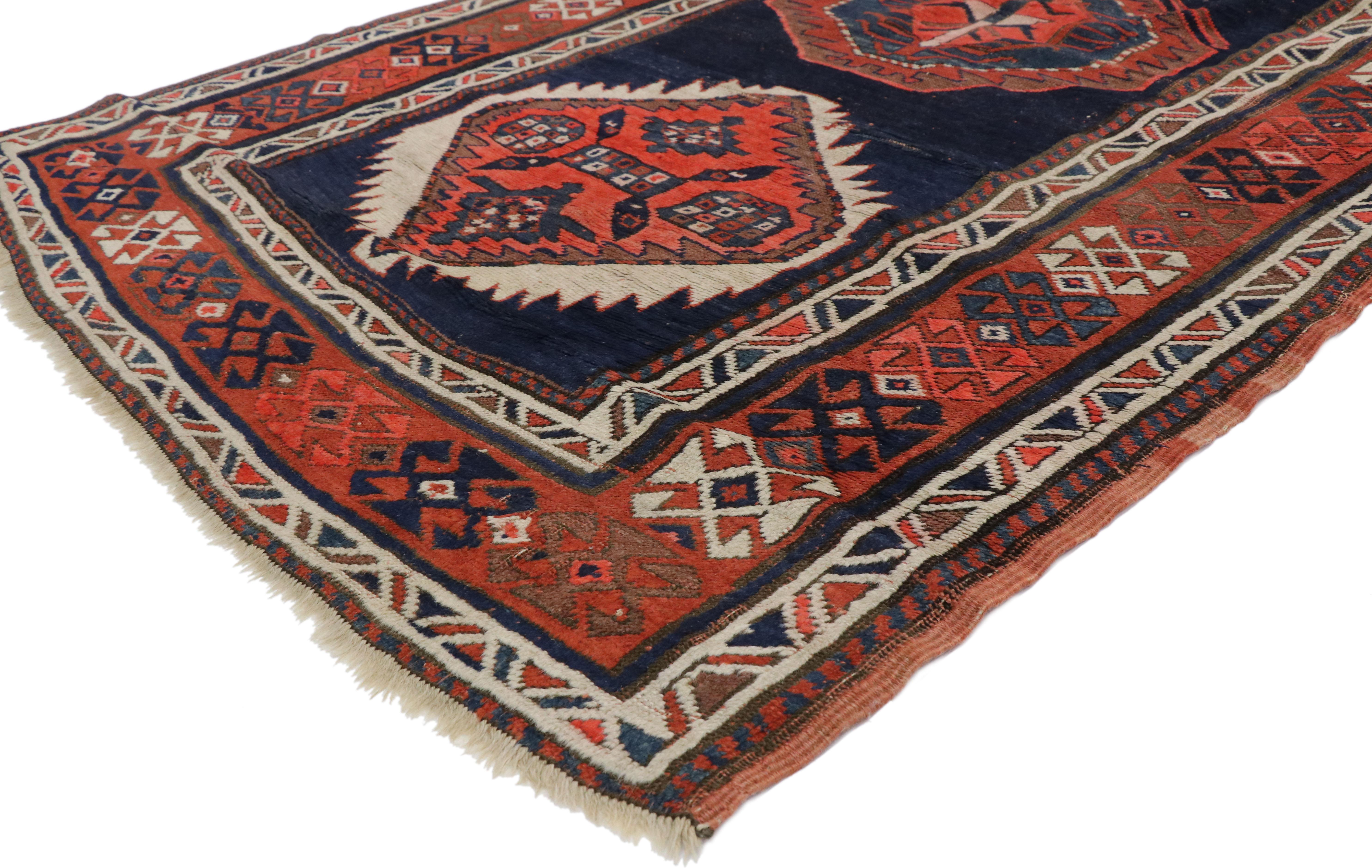 77057, antique Russian Tribal Kazak rug, Caucasian hallway runner. This hand-knotted wool antique Russian Kazak runner features alternating hexagon and octagon medallions each filled with symbolic motifs on an abrashed navy blue field. Four gazelles