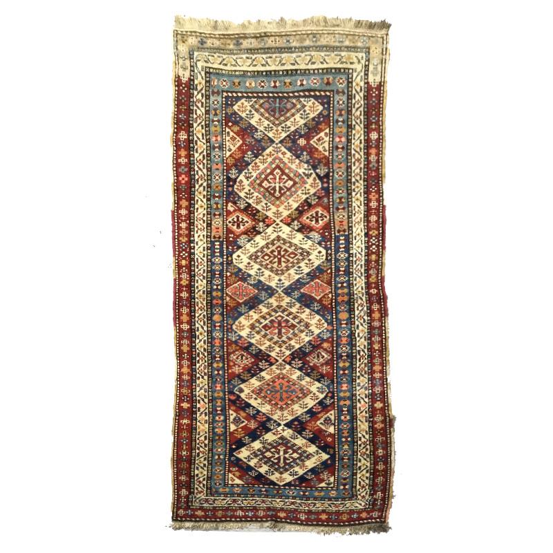 Rug from the Caucasus region
- Highlight the finesse in the execution of its geometric designs and its excellent state of conservation.
- Collection piece.
- This type of rugs are ethnic, that is, their elongated format has a marked nomadic