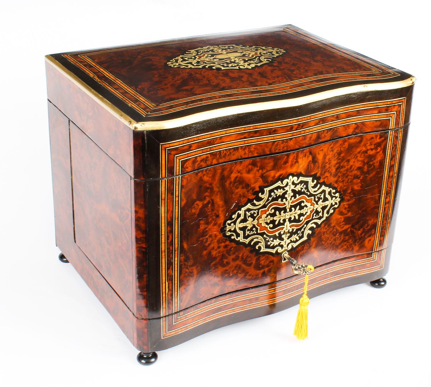 This is an exquisite antique French Napoleon III period walnut and boulle marquetry cave à liqueur, circa 1860 in date.

The tantalus has a serpentine front and a hinged lid which opens to reveal a caddy with four beautiful cut glass decanters and