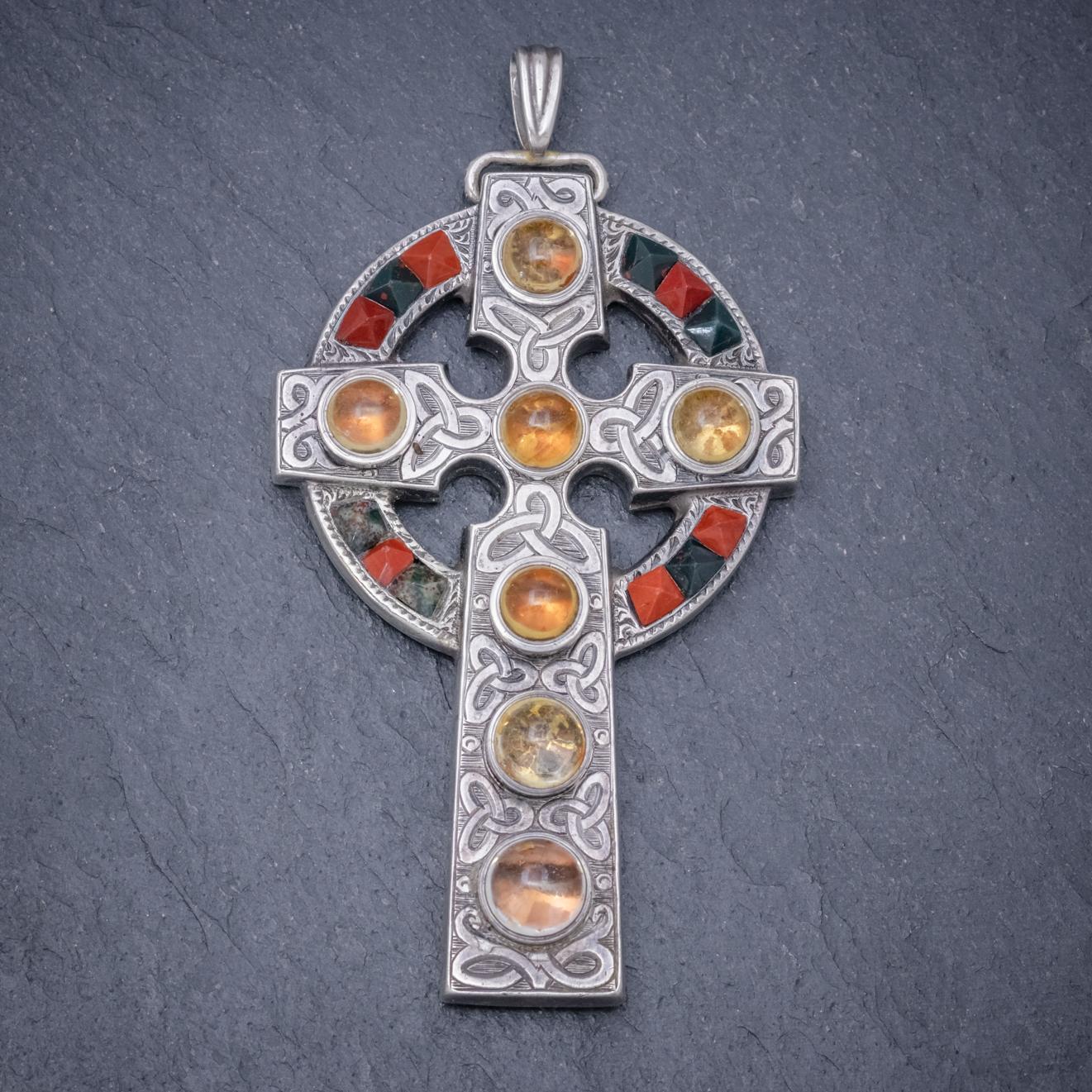 An exquisite antique Scottish cross pendant from the Victorian era decorated with pyramid cut Jasper and Carnelian stones with seven cabochon cut Cairngorms which glow with a bright golden hue.

The pendant is set in Sterling Silver and features