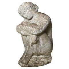 Statua antica in cemento di una donna in posa pensierosa
