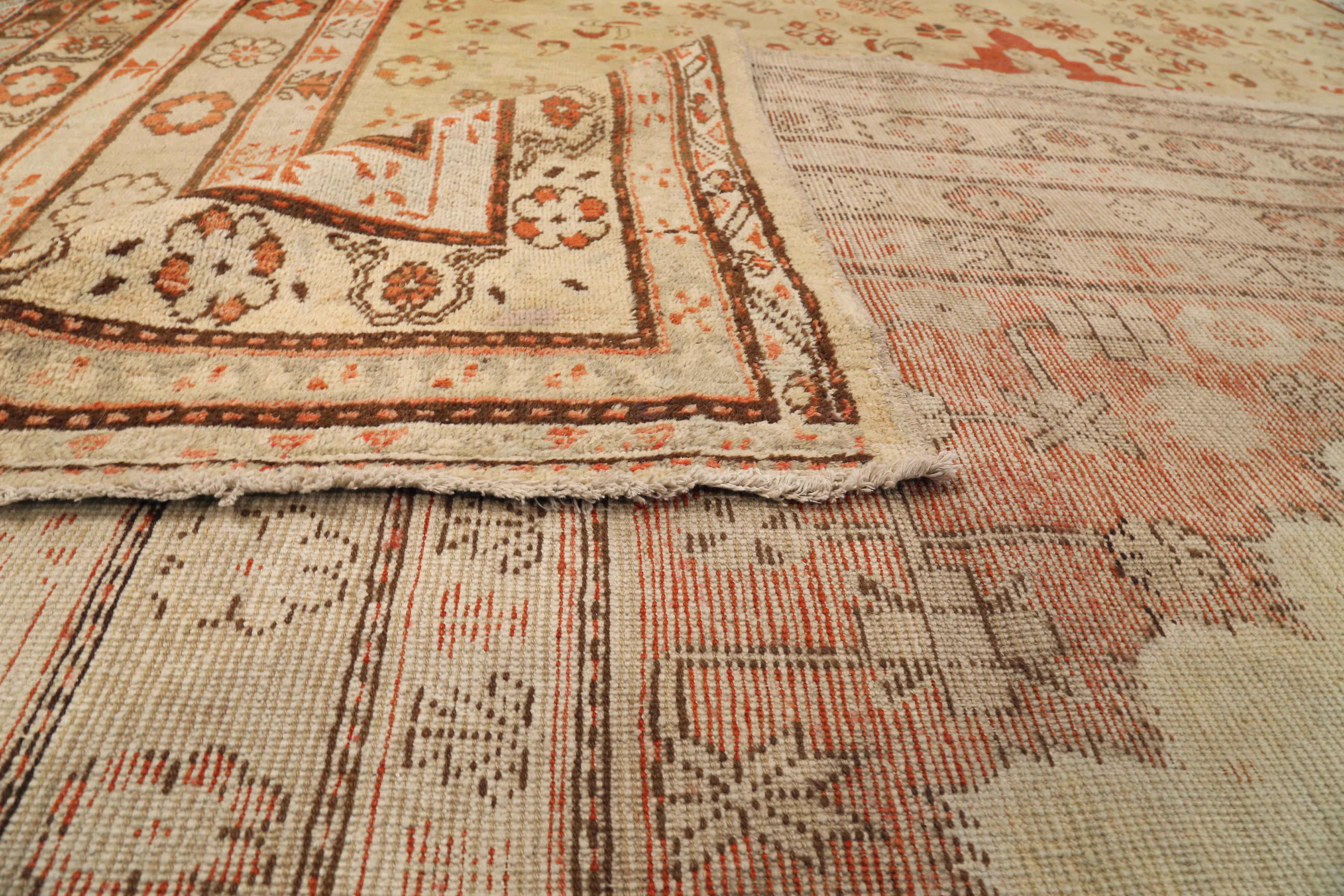 Antique Central Asian rug made of exquisite wool and the finest vegetable dyes. It exhibits a centerfield with a unique geometric design enclosed by several borders of nature-inspired and floral patterns. It’s a recurring theme in traditional rugs