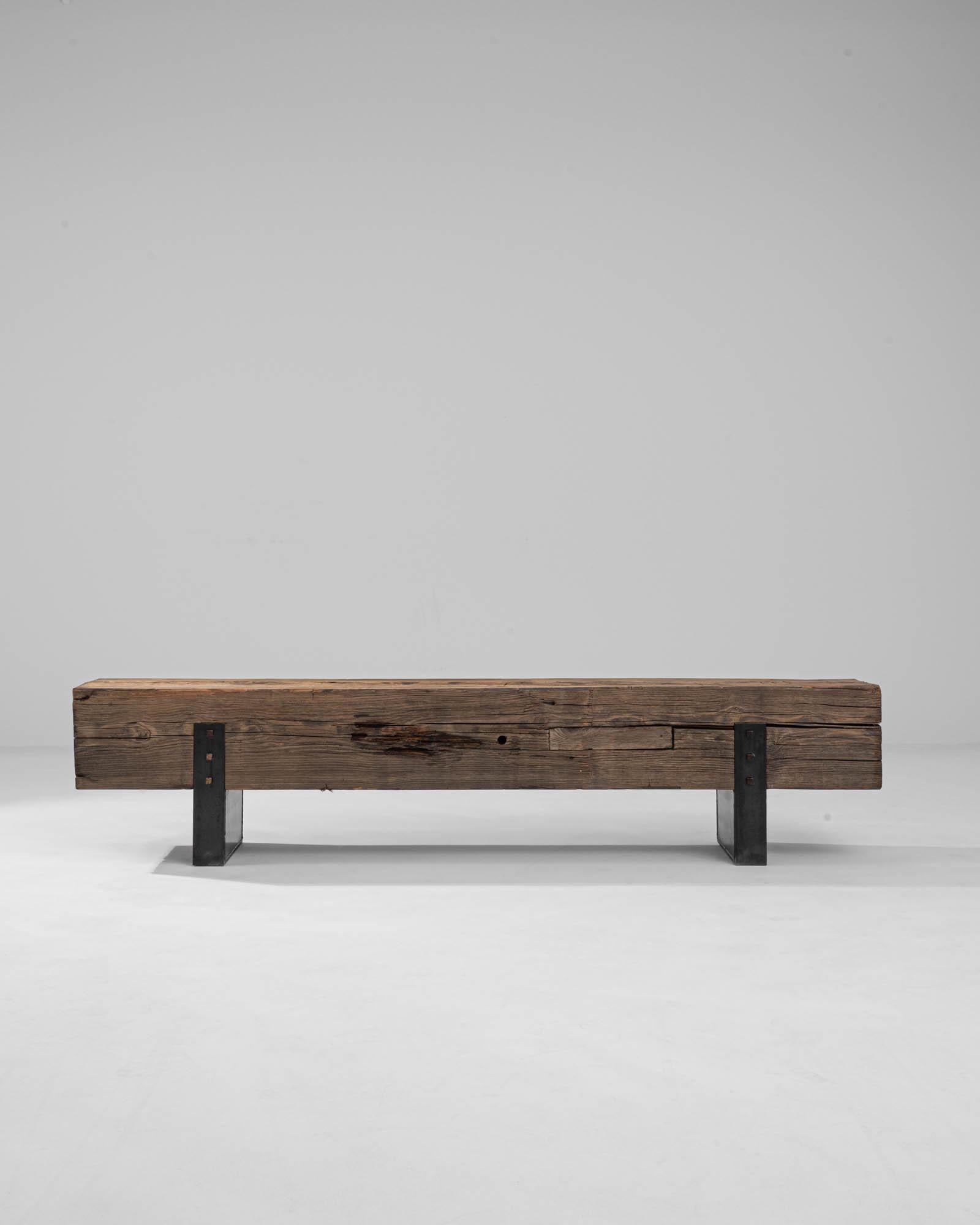 An antique Central European wooden timber has been adapted into this unique bench in our atelier. Steel rectangular feet slot precisely into the left and right side of the wooden bench to form artfully crafted, minimal feet. The bench seat, which it