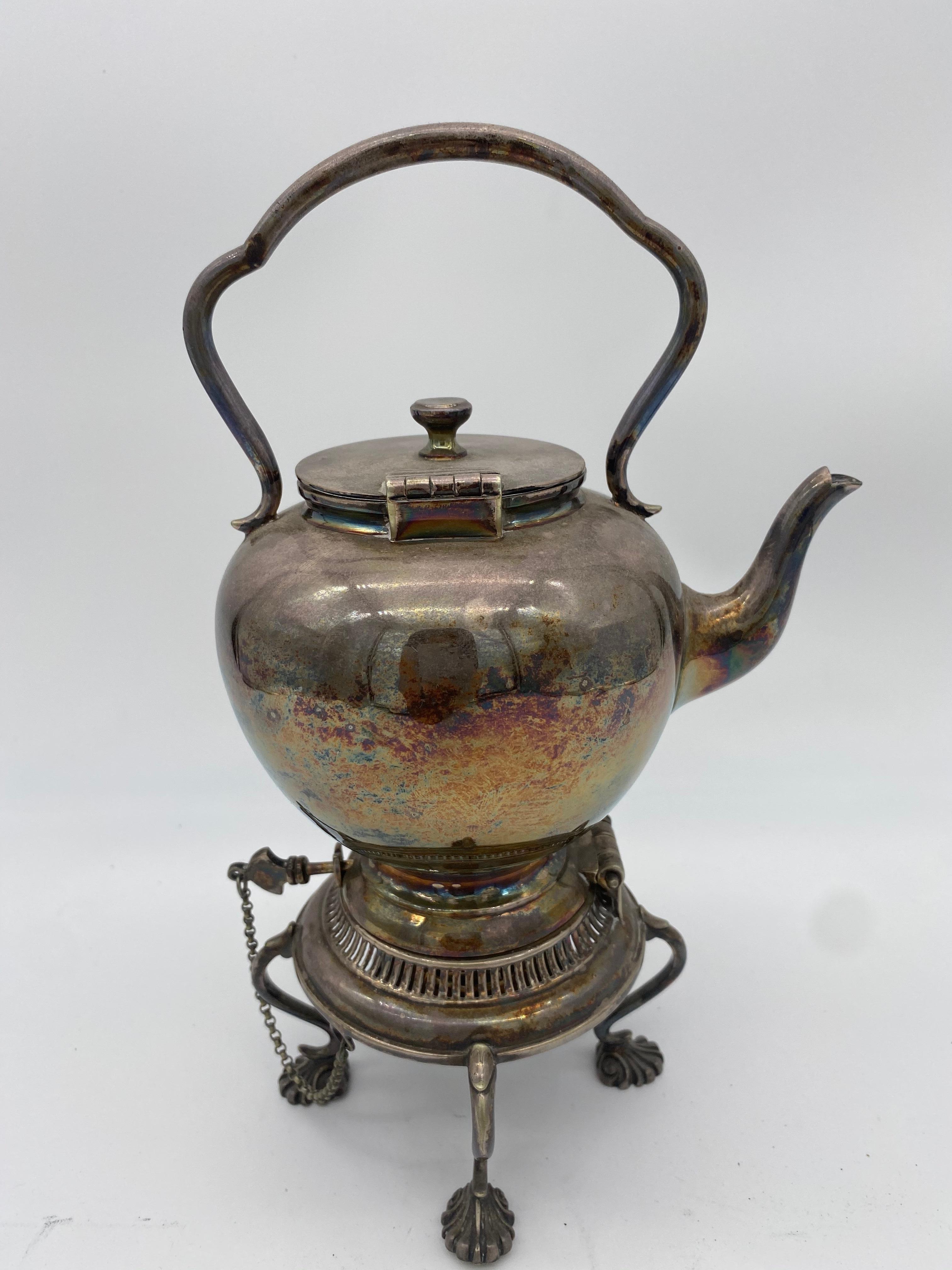 silver teapot on stand with burner