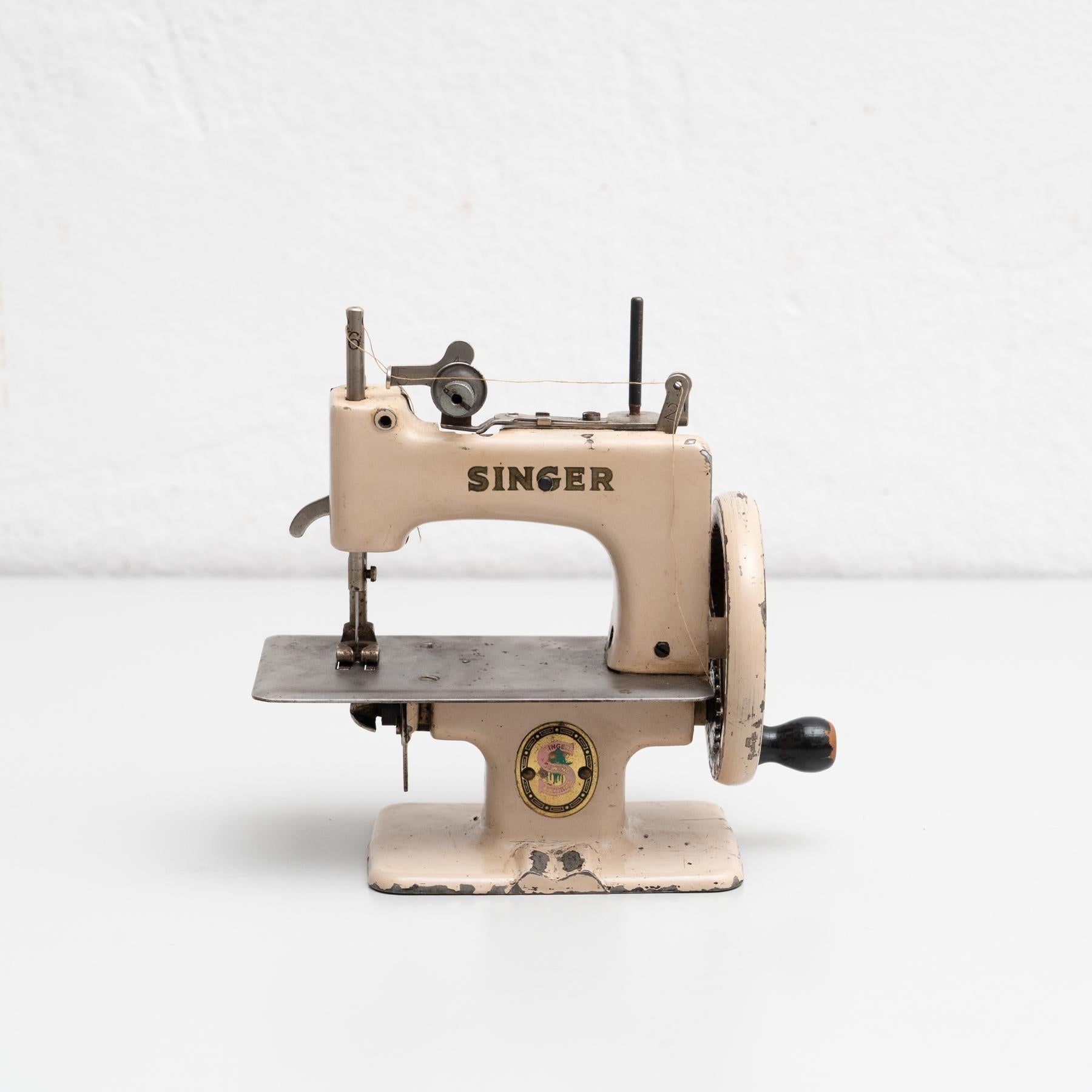 Vintage metal toy Singer sewing machine reproduction.    In original condition, wear consistent with age and use, preserving a beautiful patina.    Materials:  Metal.   