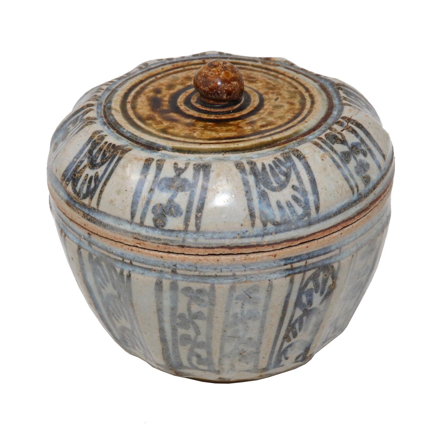 Antigua caja con tapa de cerámica de los hornos de Sawankhalok, Tailandia, de forma globular con paneles y tapa plana vidriada en marrón, con bandas incisas alrededor de un remate elevado en forma de capullo de loto, la parte del hombro de la tapa