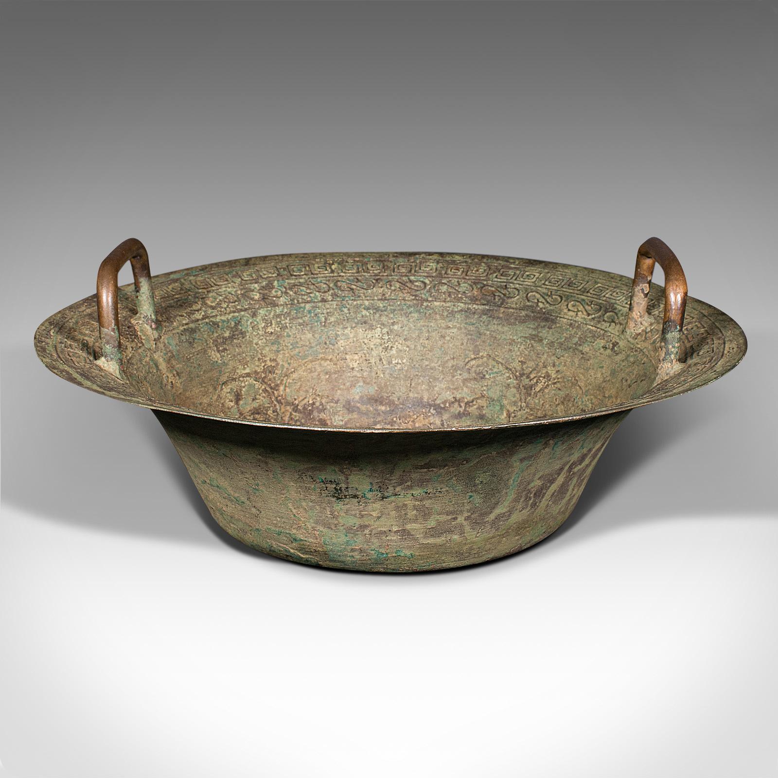 This is an antique ceremonial bowl. A Chinese, patinated brass twin handled dish, dating to the late Victorian period, circa 1900.

Heavily time-worn to distinction, for great decorative appeal
Displaying a desirable aged patina throughout
Weathered
