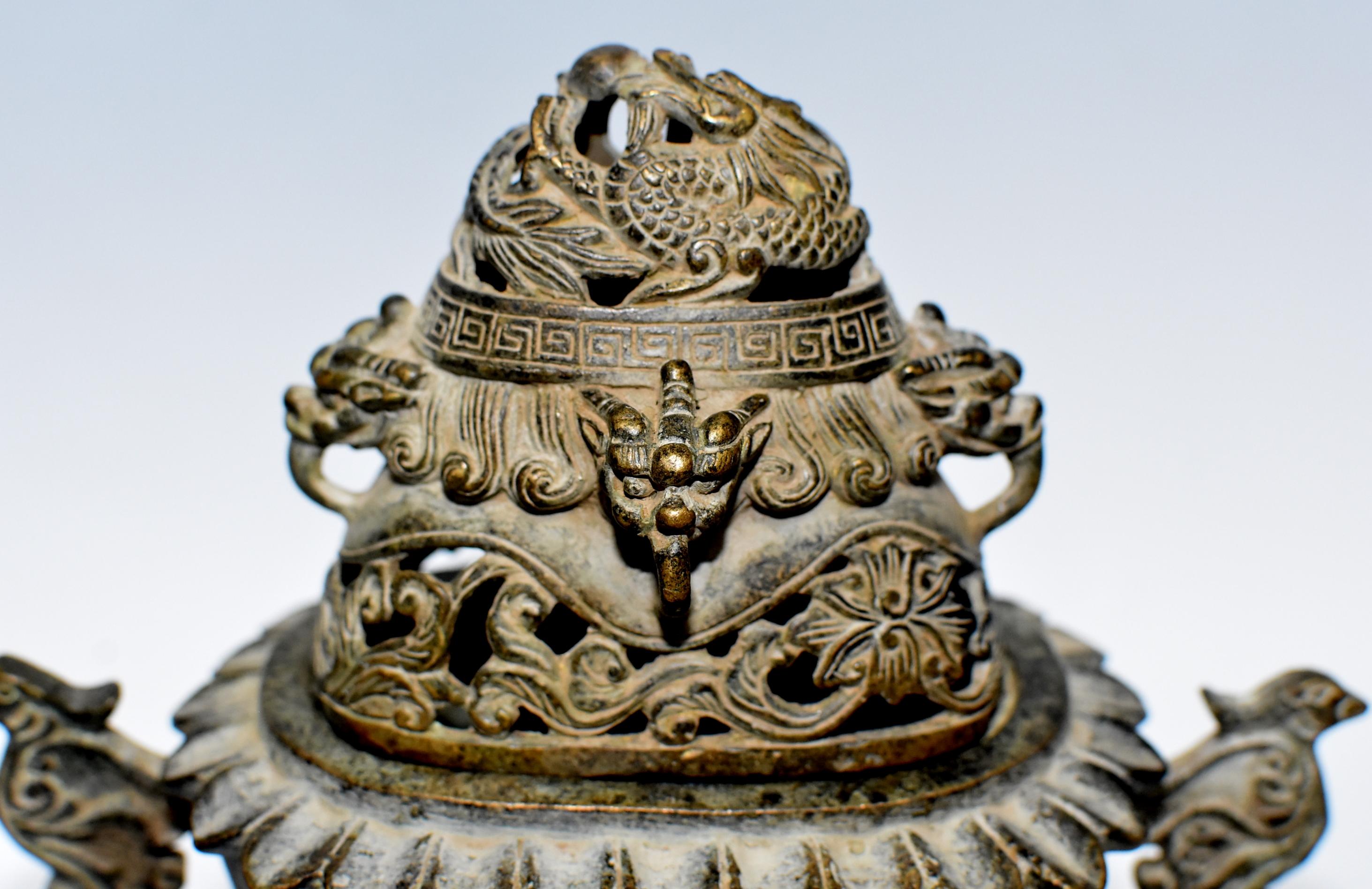 A beautiful, unique Chinese ceremonial incense burner. The pot starts with an open lotus design, followed by a pair of circling dragon and phoenix decorating the body and two ancient form birds acting as handles. A coiled dragon on the lid