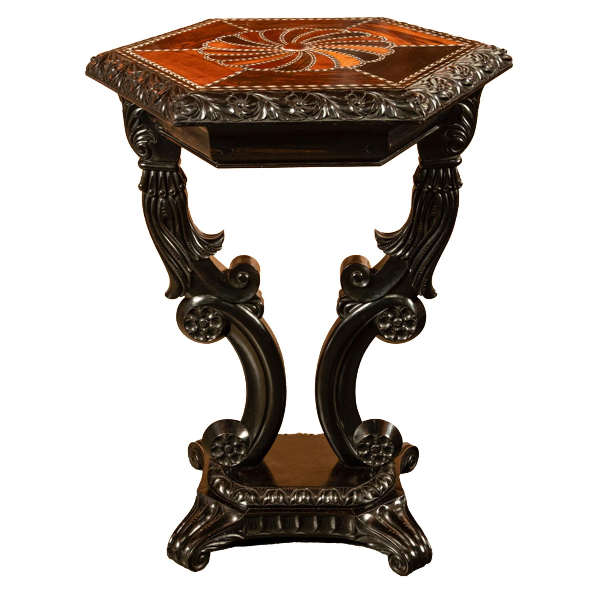 Table d'appoint en bois sculpté et incrusté d'ébène, d'une grande qualité et d'une grande ancienneté, datant du 19e siècle et provenant de la région de CIRCA, vers 1860.
Le plateau de table de forme octogonale a un bord profondément sculpté avec un