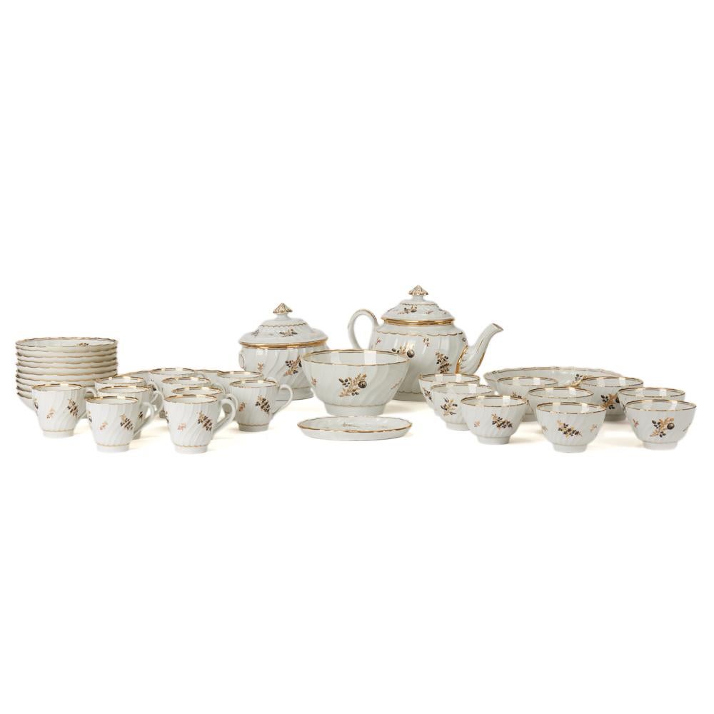 A stunning and extensive antique Chamberlain Worcester porcelain part tea set hand painted with floral designs highlighted with gilding on a white fluted body. The set comprises of a lidded teapot, a lidded sugar bowl, teapot stand, slop bowl, two