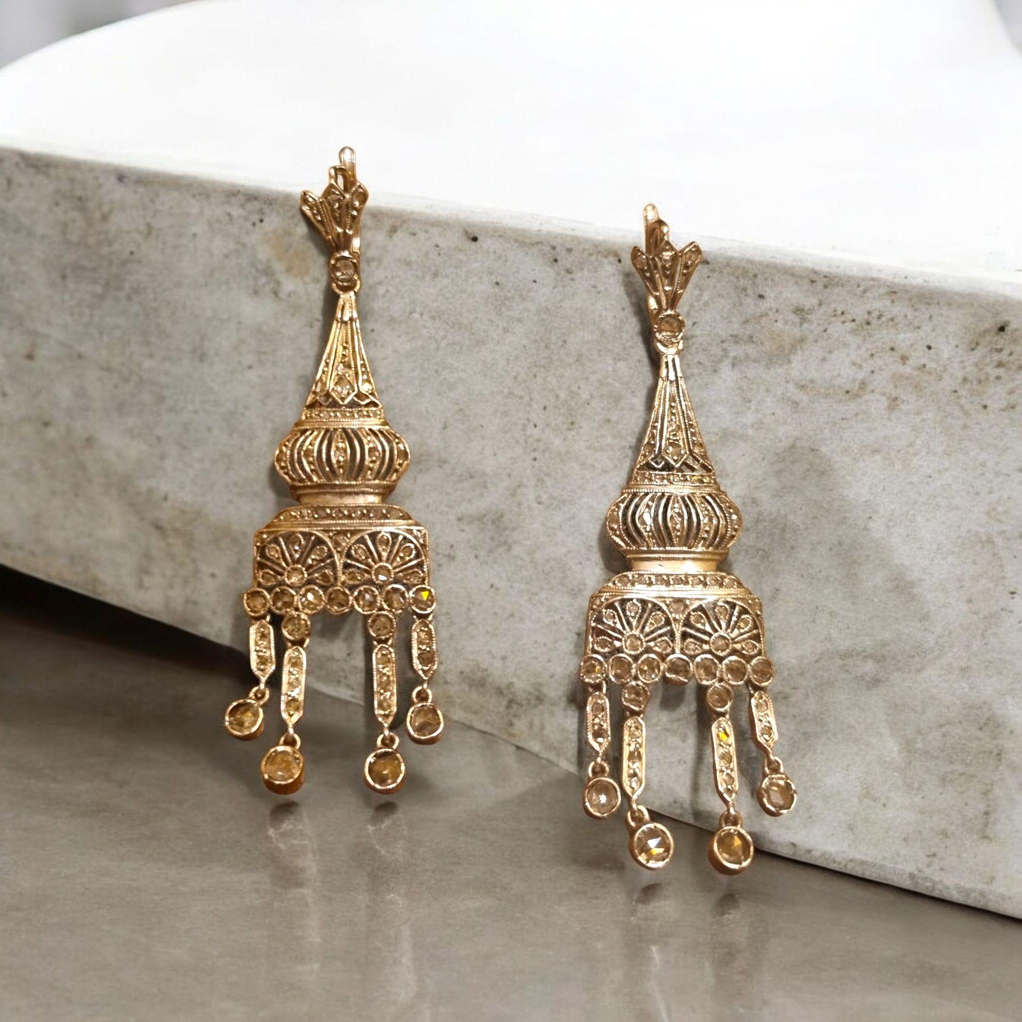 Une paire de boucles d'oreilles chandelier anciennes, finement fabriquées à la main vers 1900, présentant un ajourage complexe et des détails délicats de milgrain. Chaque boucle d'oreille est sertie de nombreux diamants taillés en rose, qui captent
