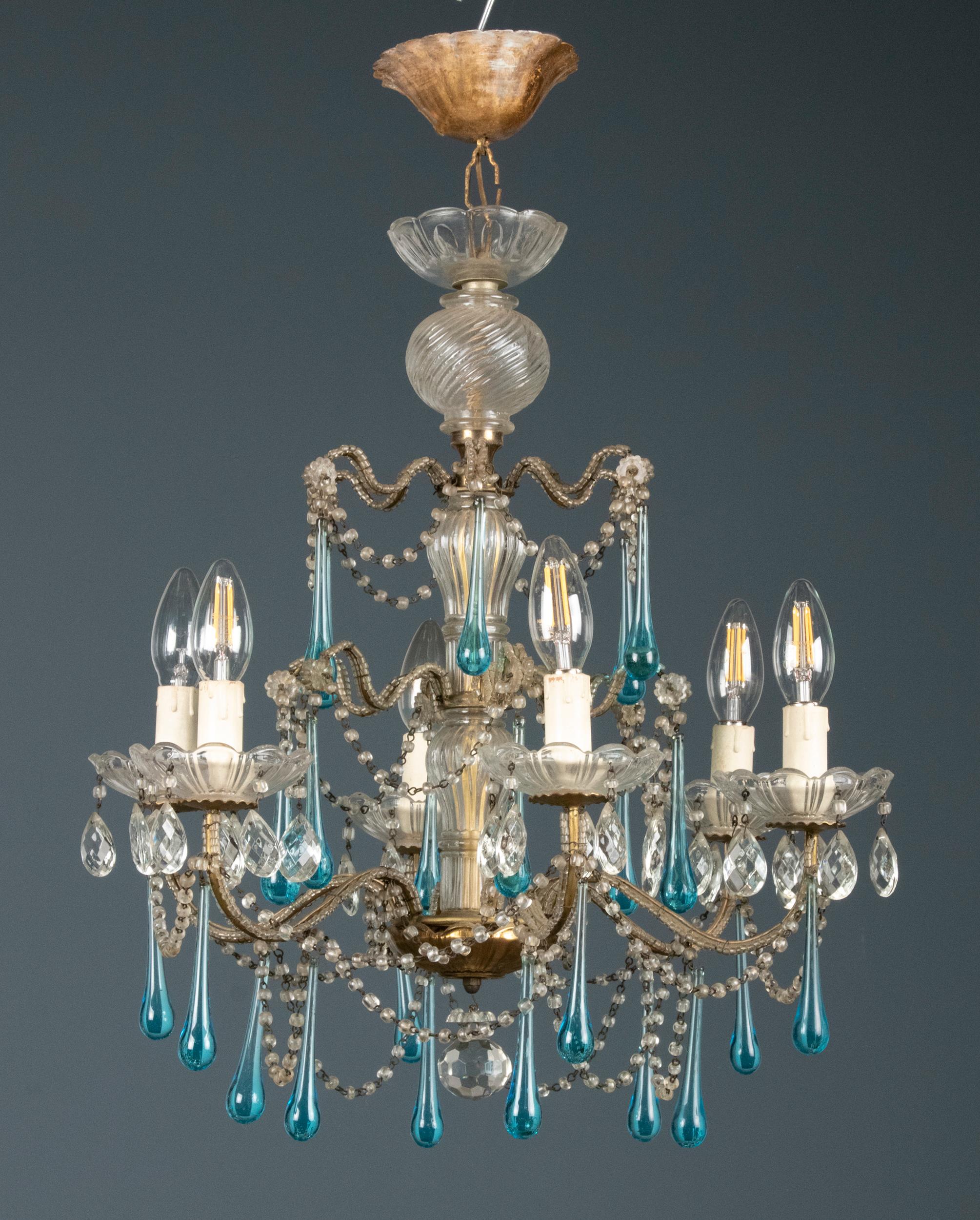 Nice antique chandelier with white and blue crystal drops.
The frame of the lamp is made of gilded iron. The lamp comes from Italy and was made circa 1920. The lamp has 6 light points.
 
