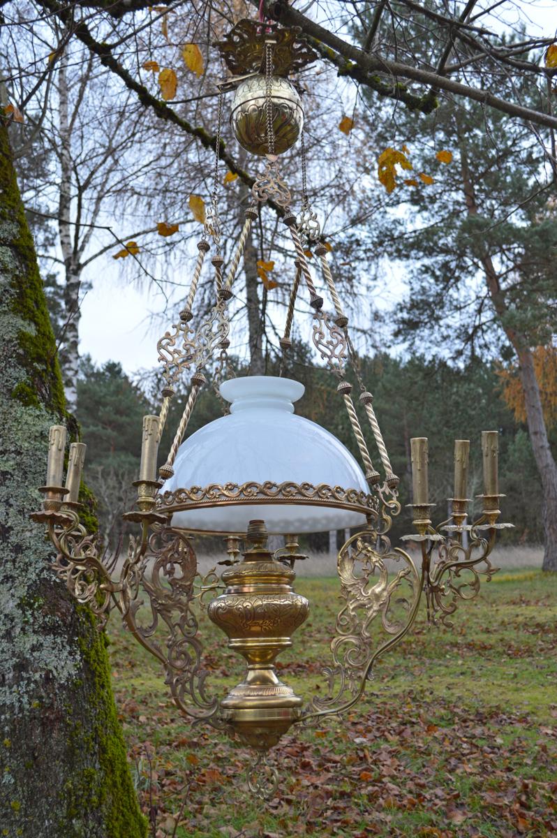 Large chandelier in bronze and brass. Three winged chimeras or dragons support the opaline lamp, late 19th century, was formerly used for candles and an oil lamp. Has been rewired, with ten lights: nine on fake candlesticks and one on the old