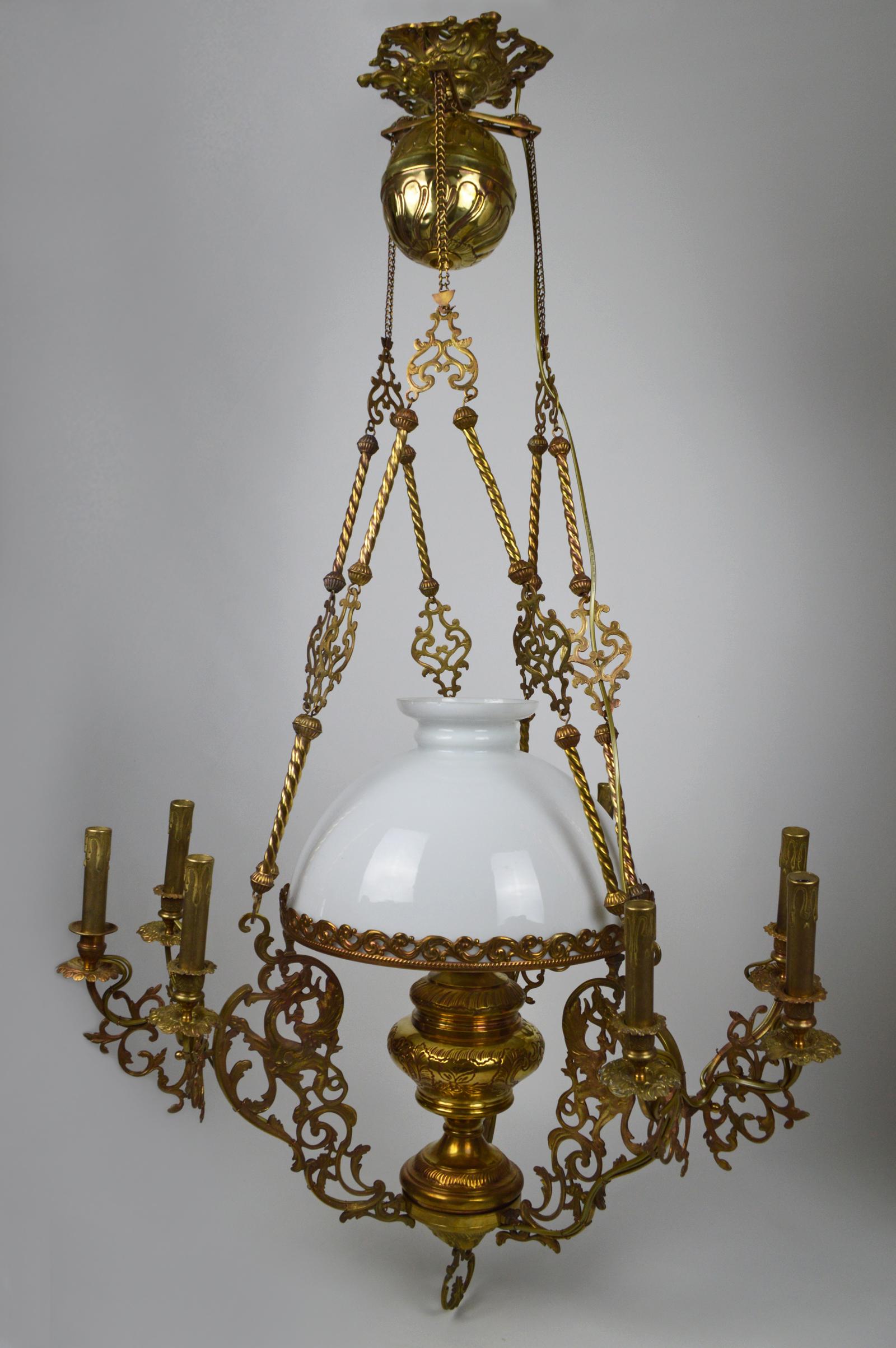 Large chandelier in bronze and brass. 
Three winged chimeras or dragons support the opaline lamp, late 19th century, was formerly used for candles and an oil lamp. 
Has been rewired, with ten lights: nine on fake candlesticks and one on the old
