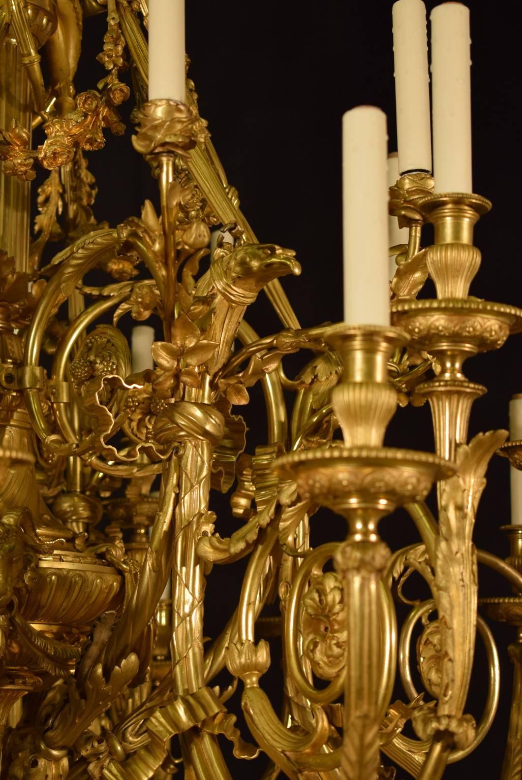 Magnificent mid-19th century chandelier, original mercury gilding showing a rich contrast of matte and burnished areas. The chandelier features a profuse array of Neoclassical ornaments such an a stylized eagle head issuing arms ending in elaborate