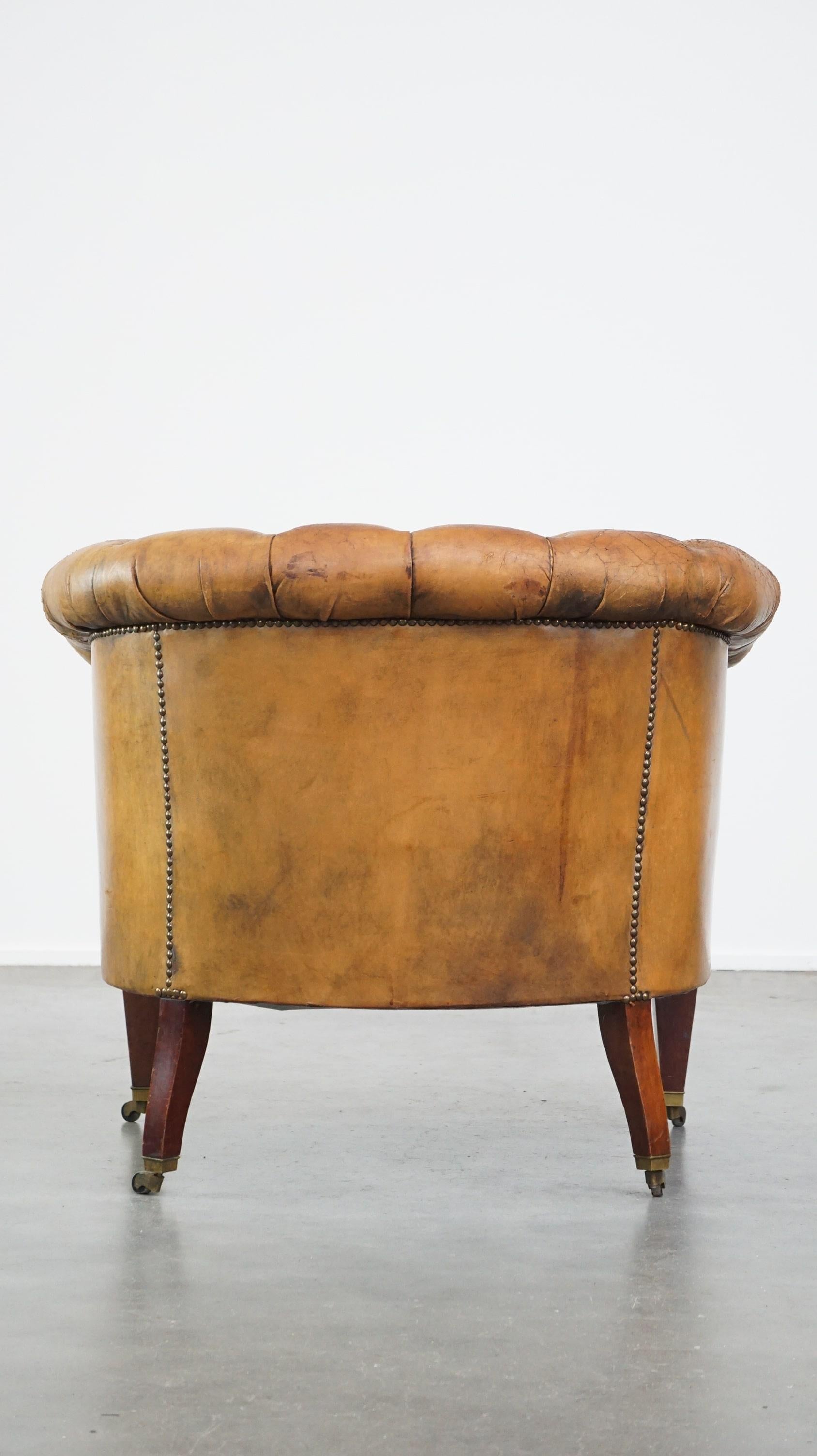Hand-Crafted Antique, characteristic sheepskin chesterfield club chair on wheels For Sale