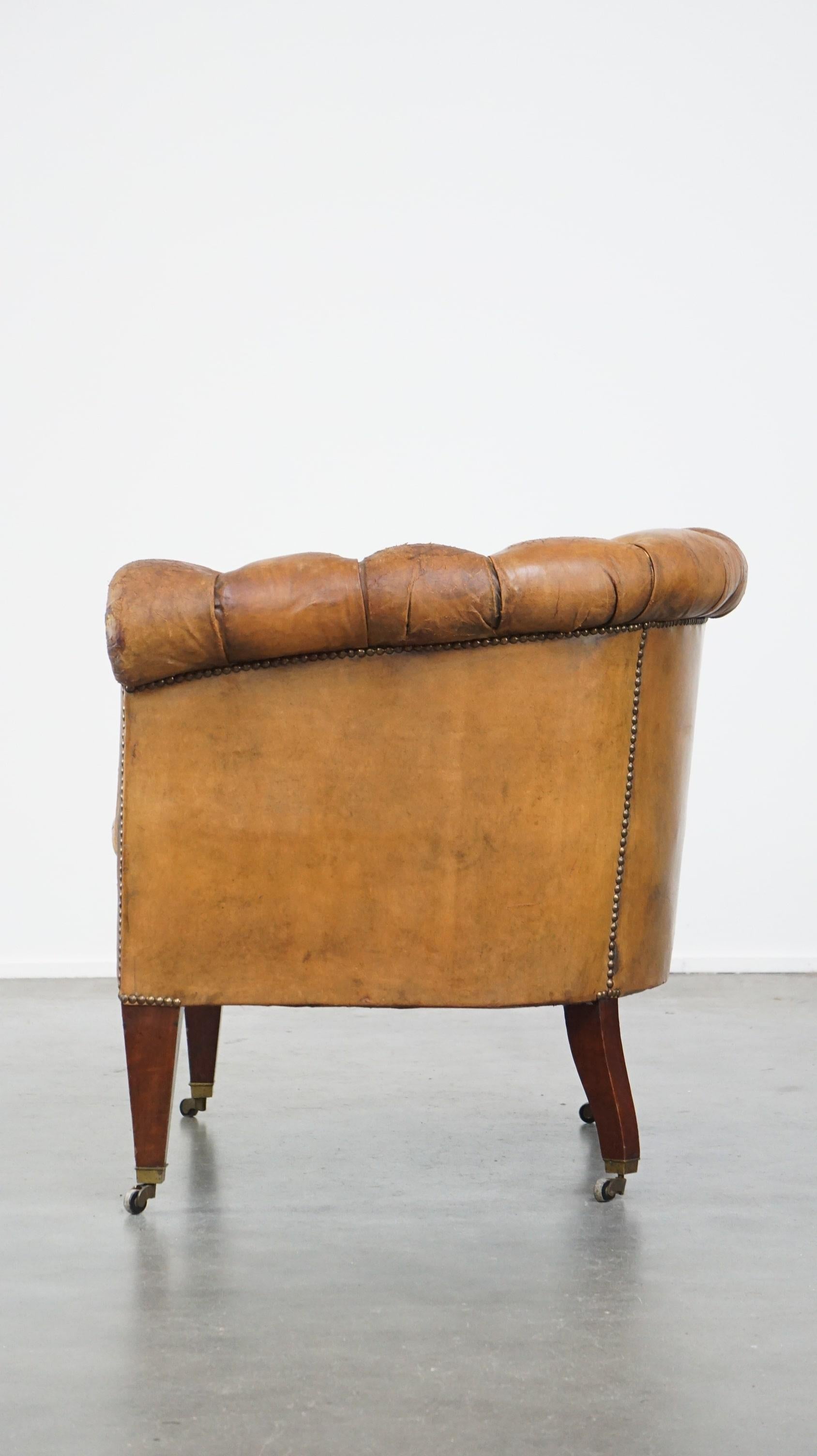 Antique, characteristic sheepskin chesterfield club chair on wheels In Distressed Condition For Sale In Harderwijk, NL