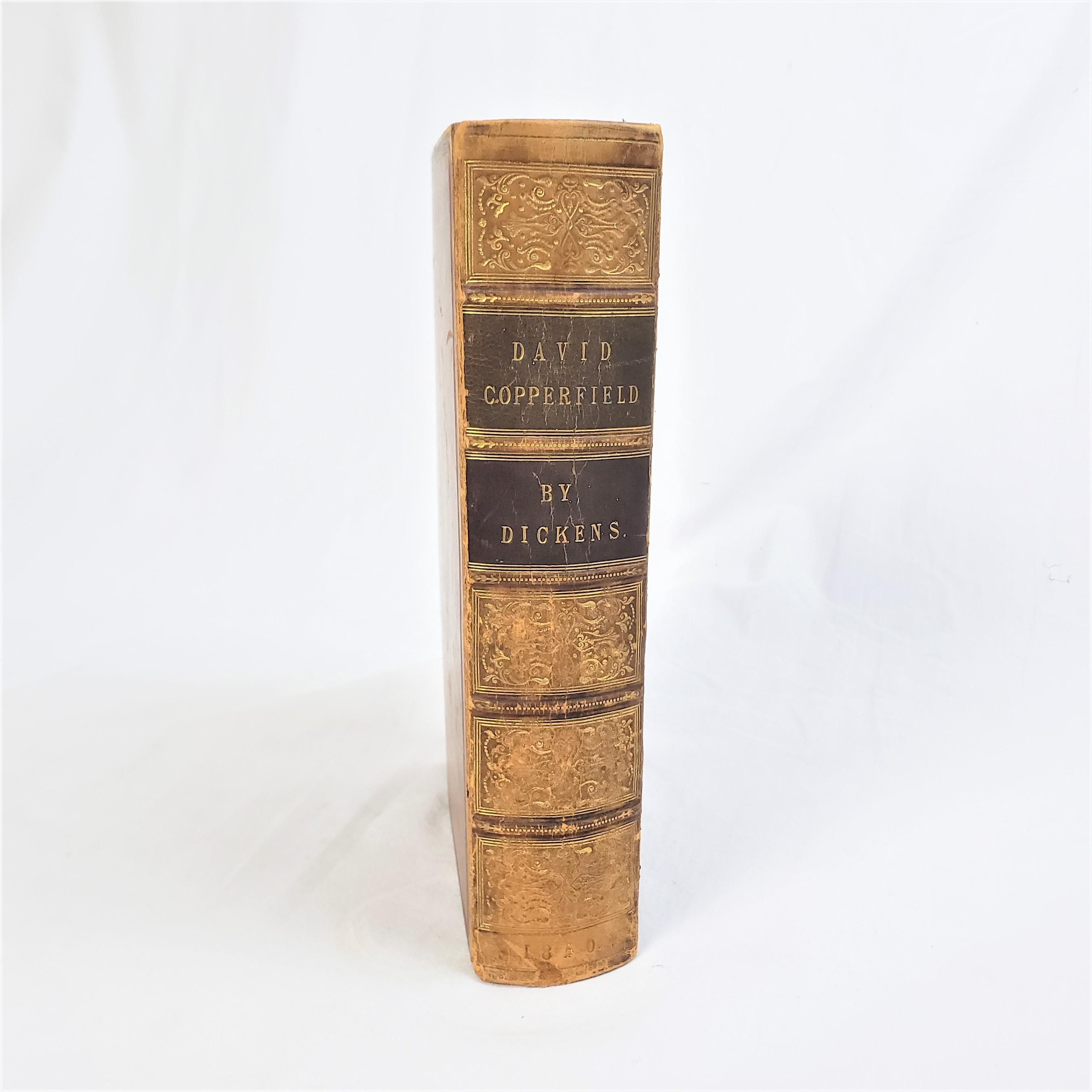 This antique 1st edition book titled David Copperfield was authored by Charles Dickens and published by Chapman and Hall of England in 1850 in the period Victorian style with etchings by Hablot Knight Browne 