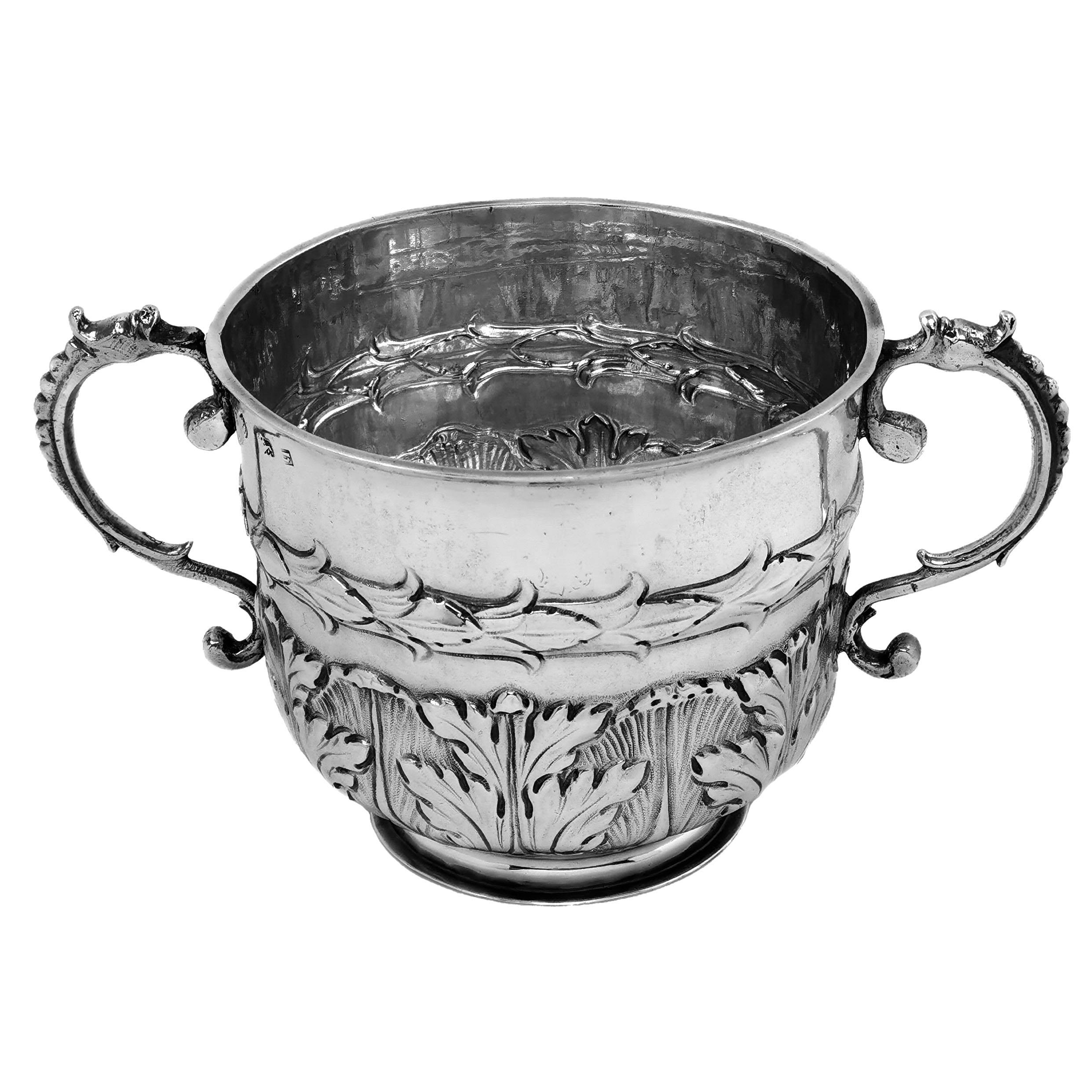An impressive Antique Charles II sterling Silver Porringer of substantial size decorated with a chased stylised leaf pattern around the base and a chased band around the middle of the body. The Porringer has a pair of scroll handles.

Made in