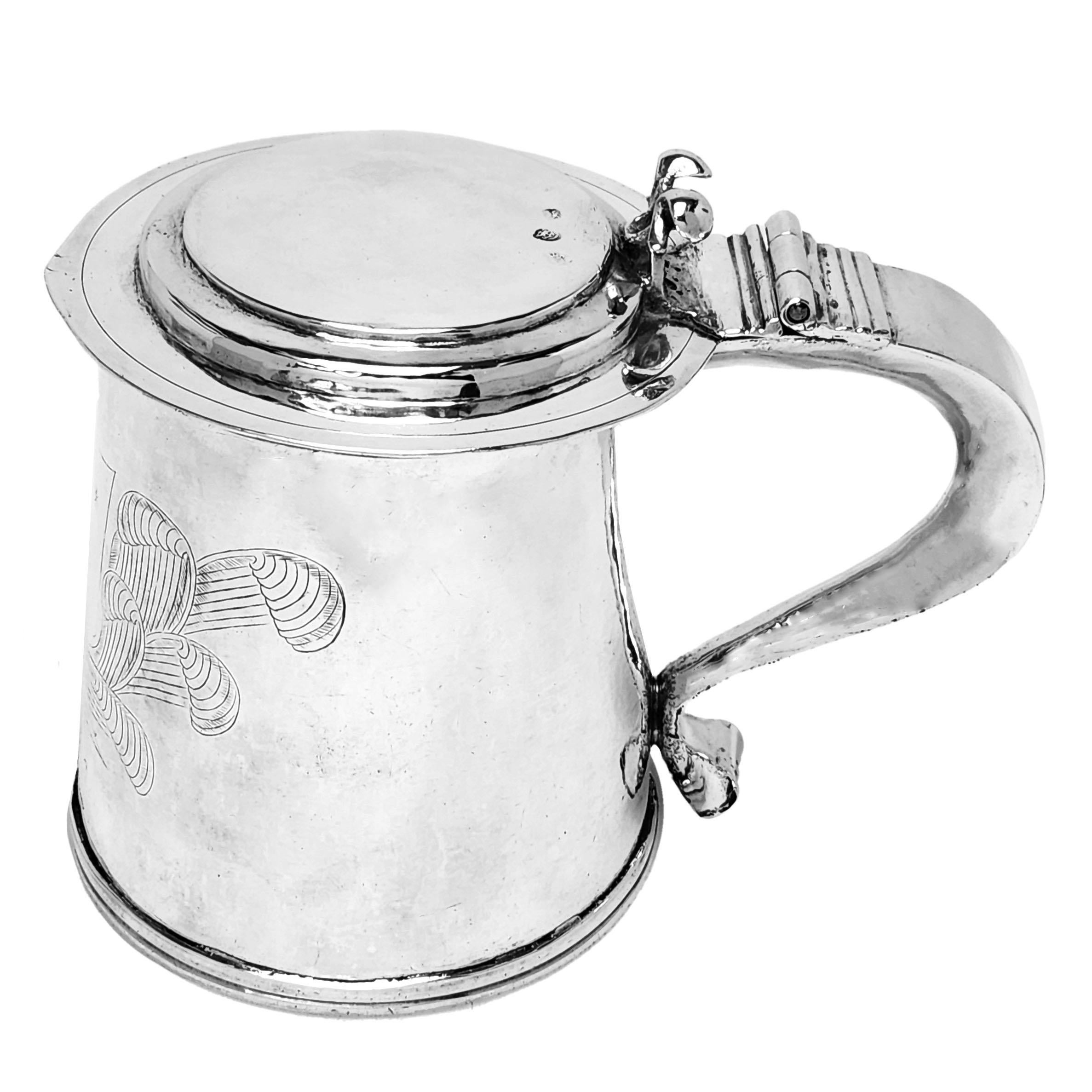 A magnificent Antique Charles II Lidded Tankard with a traditional straight sided tapered body. The Tankard has an large engraved armorial opposite a substantial scroll handle. The 17th century Tankard has a flat hinged lid with a curved thumb