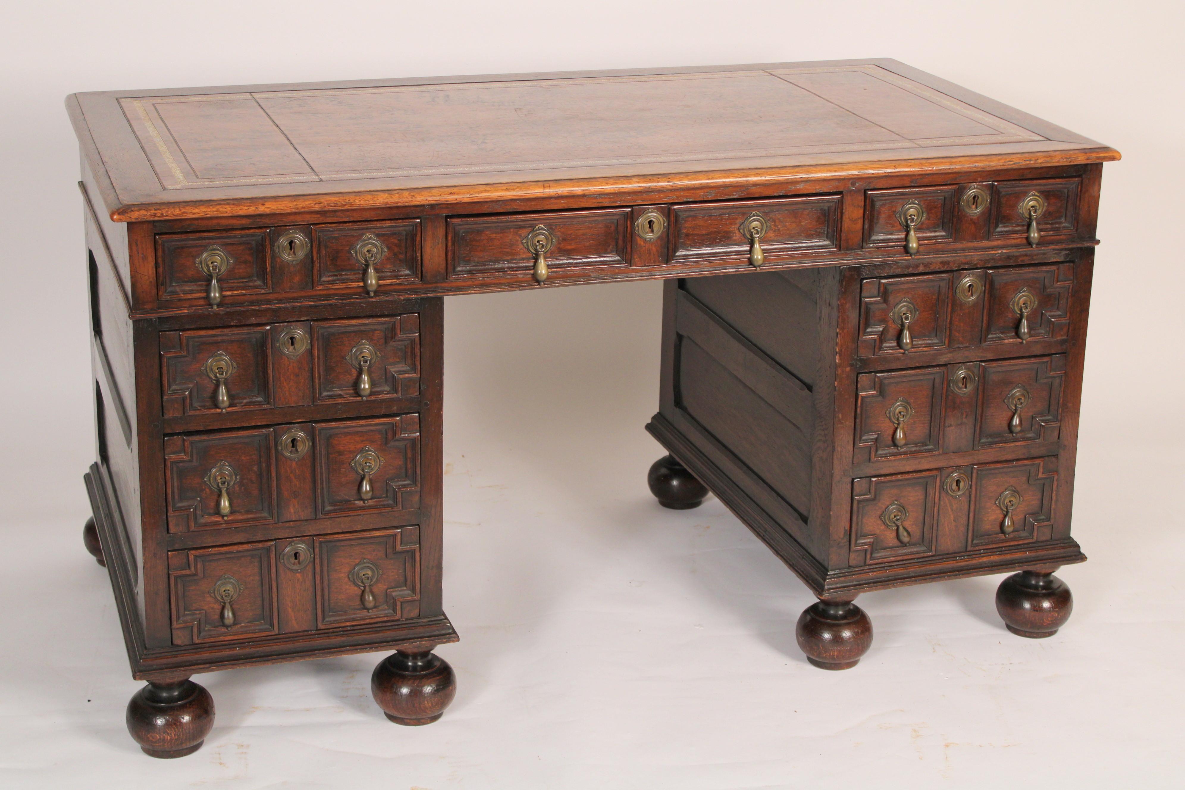 Charles II style oak double pedestal desk with a tooled leather top, circa 1920's. With a very nice old rectangular tooled leather top, 3 frieze drawers and two pedestals with 3 drawers each resting on ball feet. Wood has nice color, exceptional
