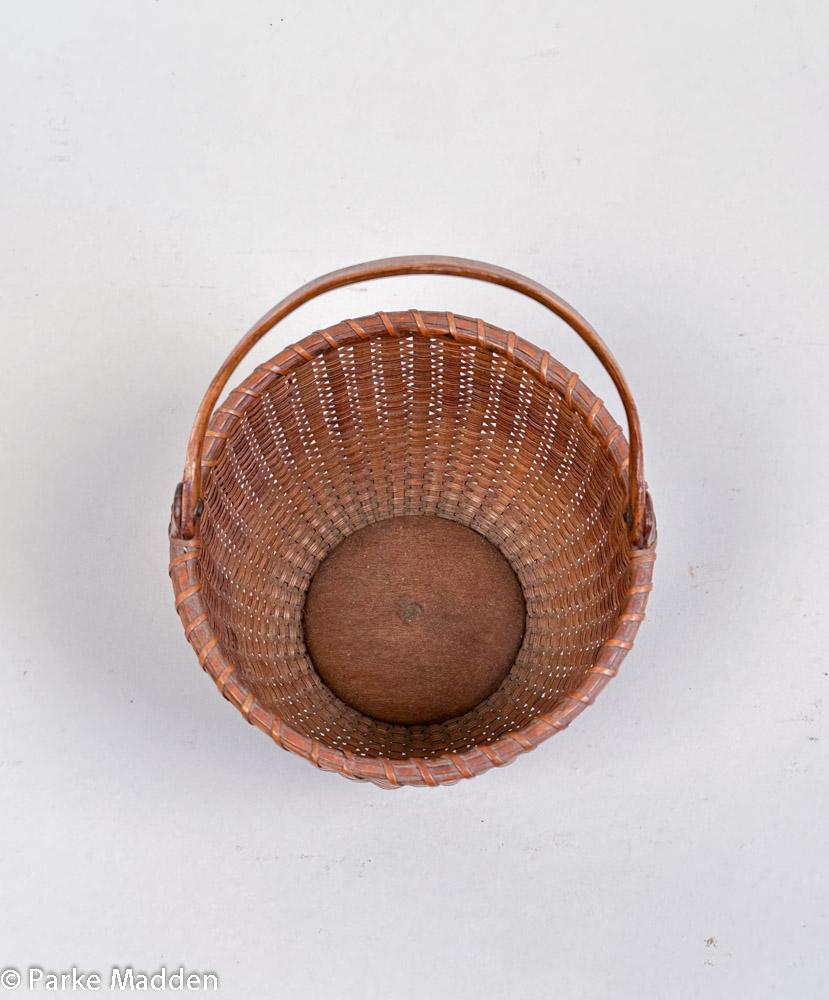 Antico cesto per nave da crociera di Nantucket, attribuito a Charles Ray (1798-1884) intorno al 1870. Cestino rotondo aperto in canna con doghe in rattan, manico intagliato con estremità ovoidali montate con rivetti metallici su orecchie