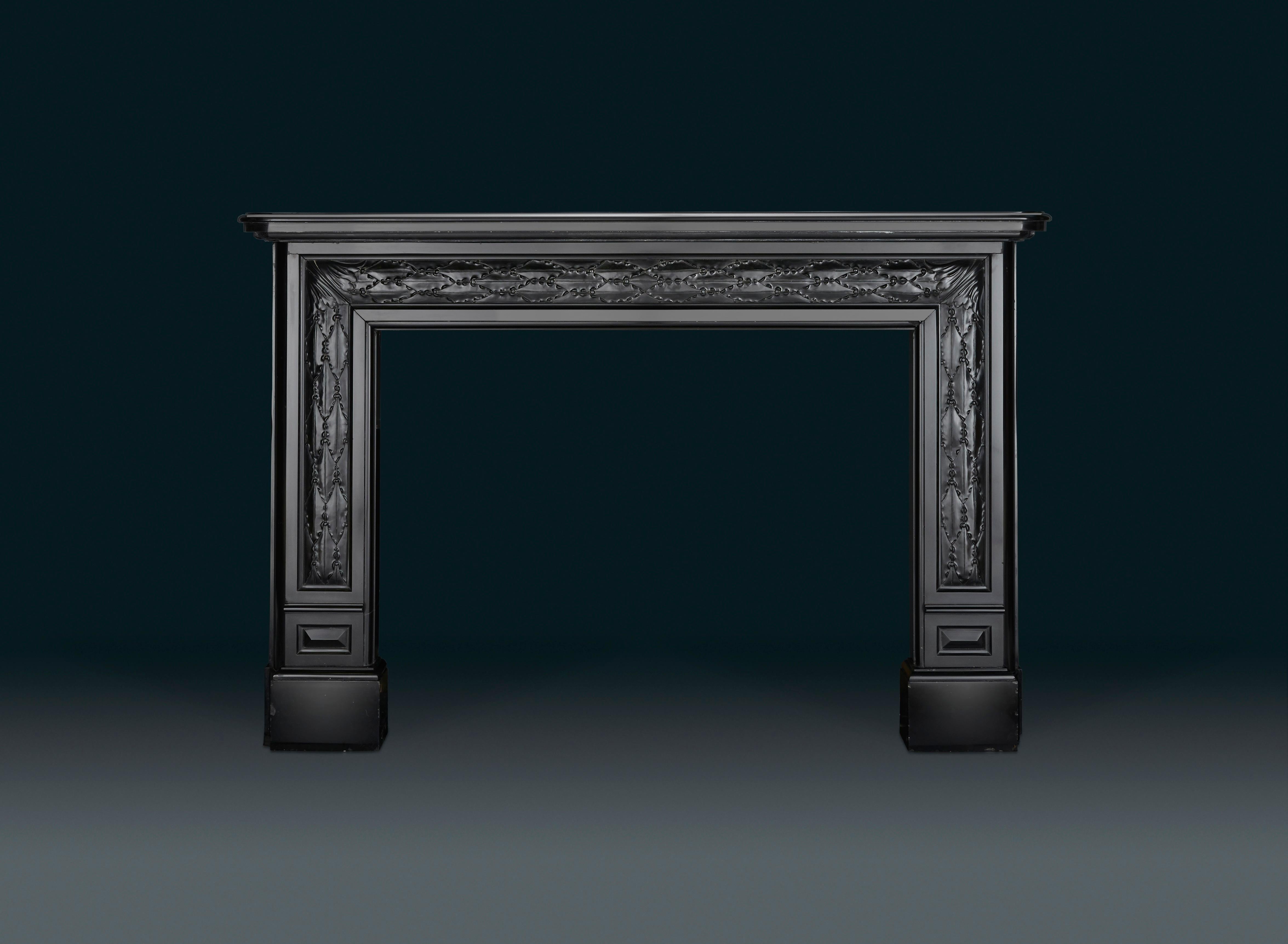 An unusual French, early 19th century Charles X (1824-1830) black marble chimneypiece of earlier Louis XVI rectangular shape. The oblong rectangular shelf with rounded corners, the frieze and jambs with inset stylized elongated leaf and berry