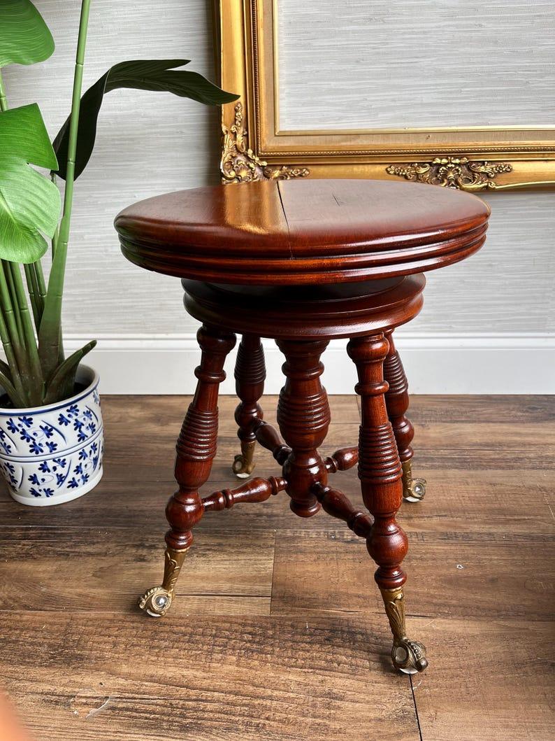 Dimensions:
Fully raised: 22” tall apx
Standard Height: 18” tall apx

Add a touch of history and charm to your home with this Victorian-era piano stool from circa 1900. Made by the renowned H. Holtzman & Sons, this beautifully crafted piece features