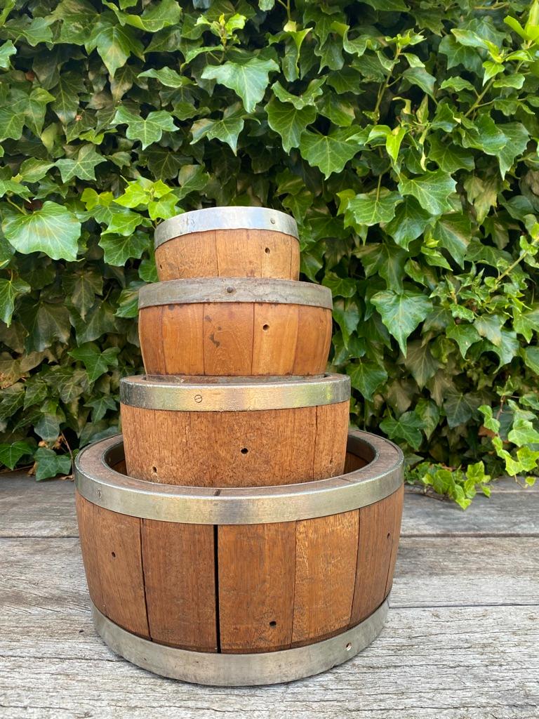 This set of four old Dutch wooden cheese molds with metal bands and matching pressure lid (only the smallest mold doesn't have a lid). 
Four original wooden cheese kegs in which Gouda cheese was made in the traditional way. Made from curved
