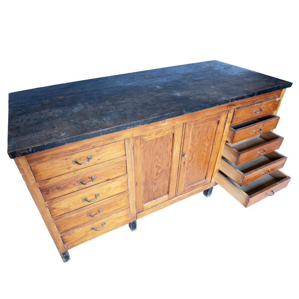 Questo antico mobile da farmacia in legno massiccio vanta un robusto piano in pietra che offre funzionalità e carattere. Dispone di un grande mobile centrale a due ante e di cinque cassetti su ciascun lato, per offrire un ampio spazio di