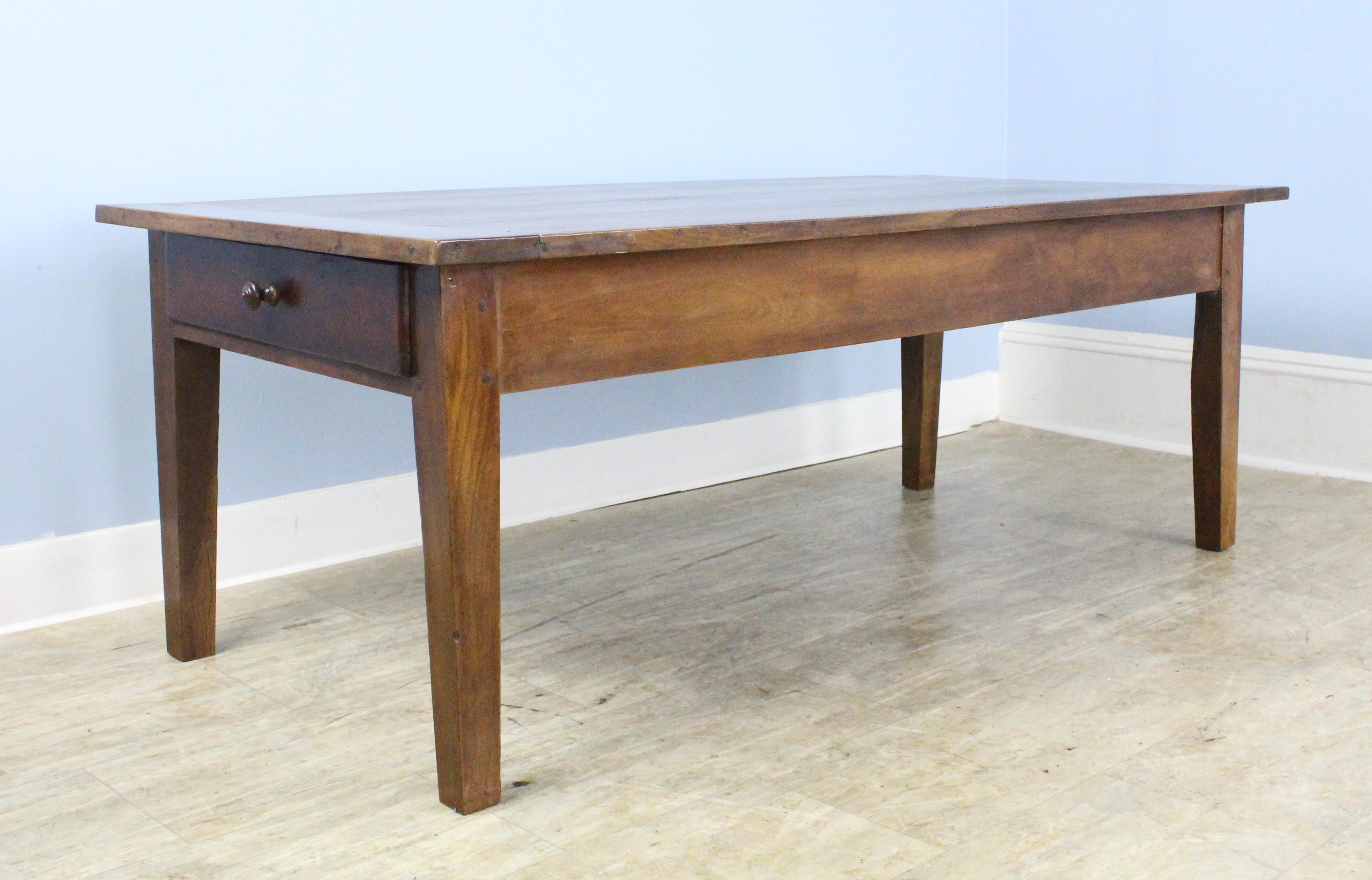 A simple, classic cherry farm table with a drawer at either end, in very good, clean condition. Beautiful cherry grain and color, with lovely glossy patina.  Top has been shimmed, shown in thumbnails.