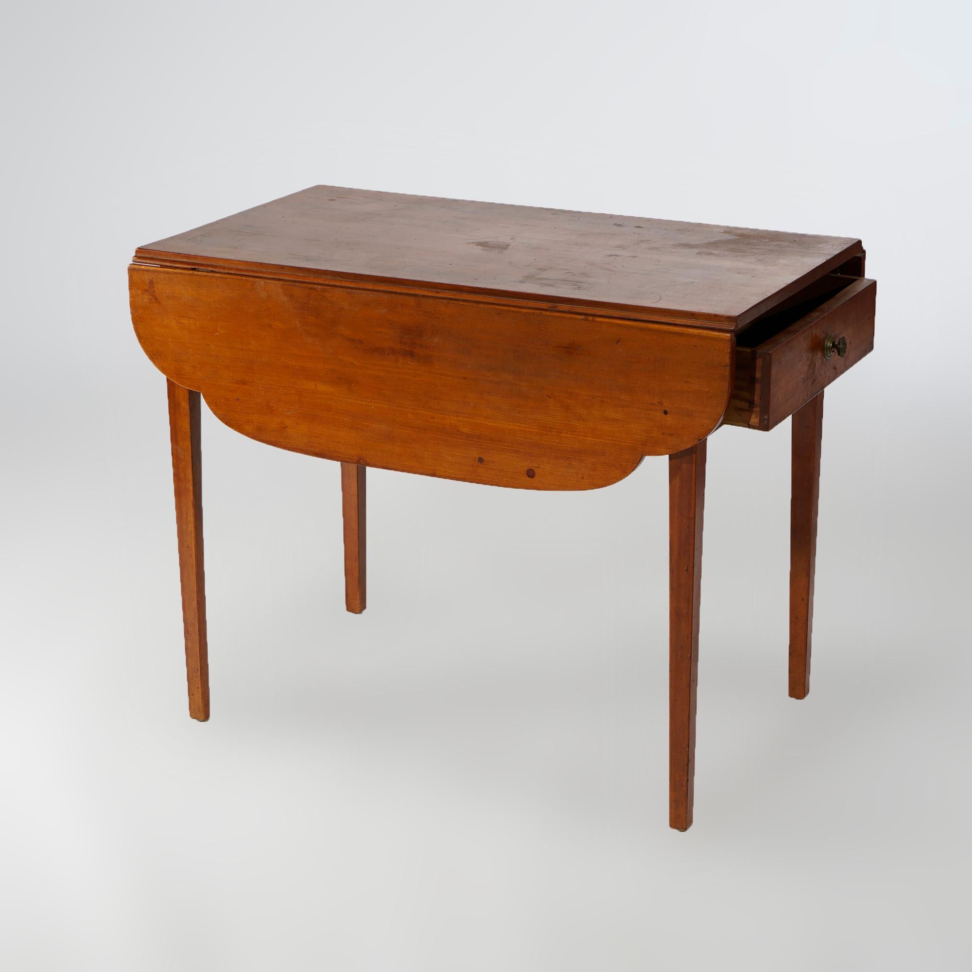 An antique Pembroke table offers cherry construction with shaped drop-leaf top over single drawer, raised on square and tapered legs, c1820

Measures- 28.5''H x 35.5''W x 21.5''D folded; 28.5''H x 35.5''W x 39.25''D open

Catalogue Note: Ask about