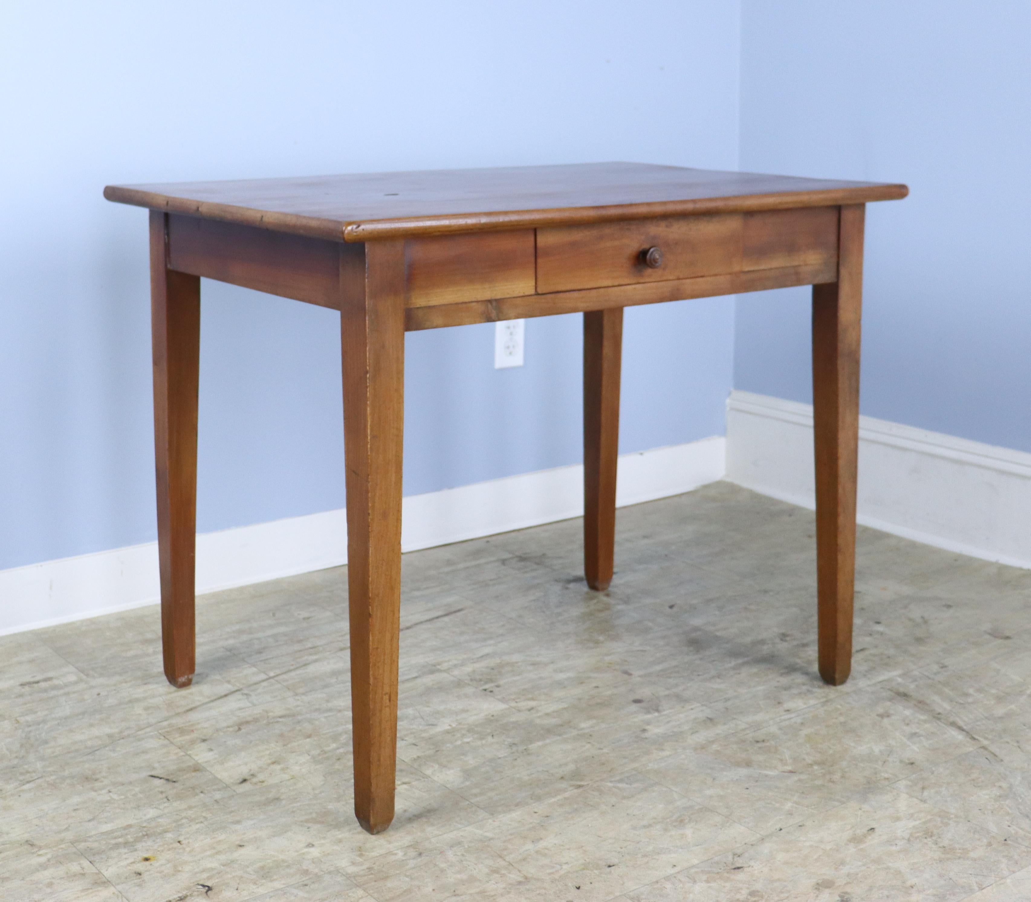 A simple handsome side table or smaller writing table/desk in vibrant cherry. Classic tapered legs and a single drawer. We have put this table in the writing table or desk category because while it would make a good side, end or lamp table, it has a