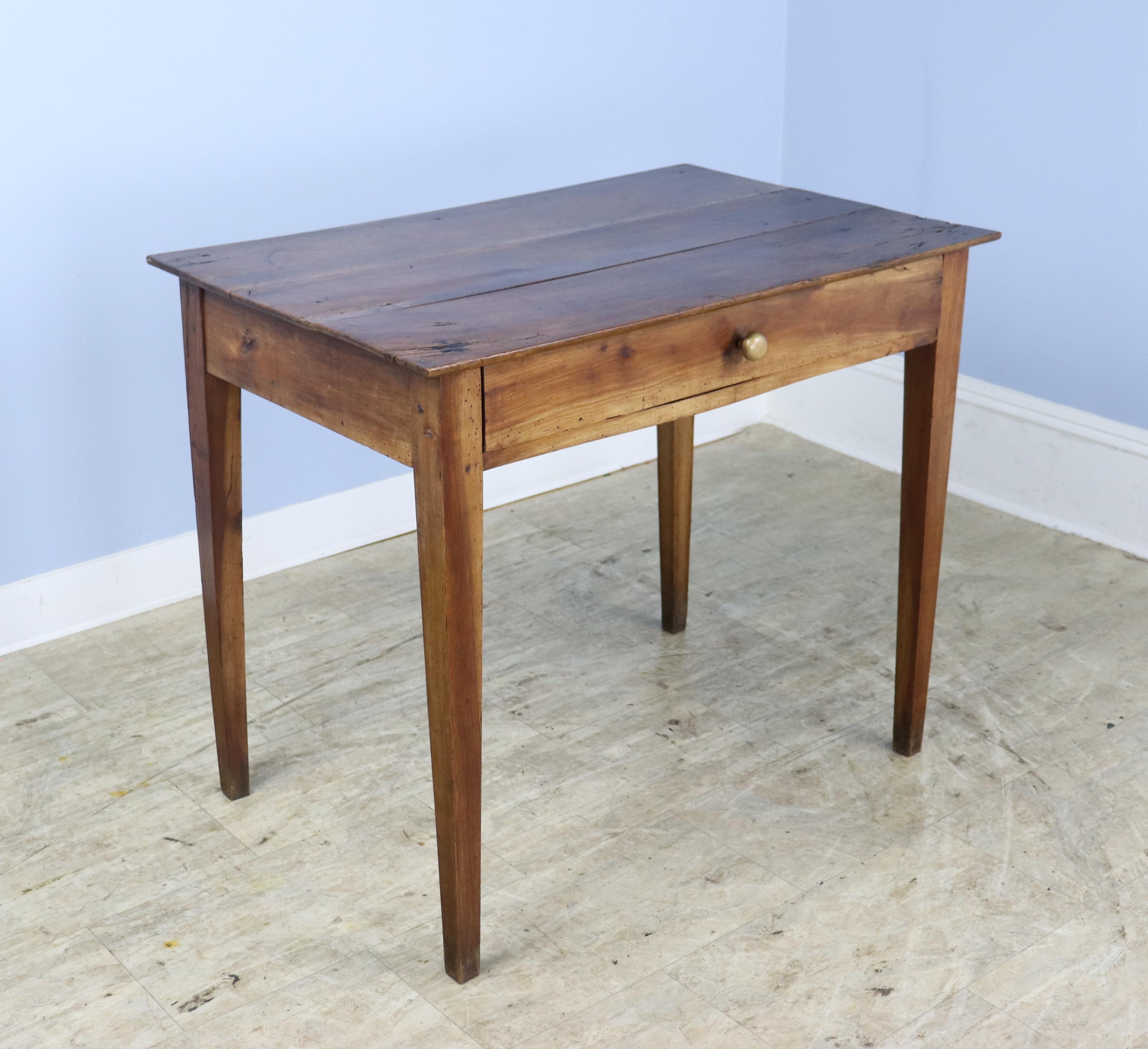 A mid 19th Century side table in warm cherry with classic tapered legs.  The top has good distress and character, well patinated over the years.  Single drawer slides easily.  