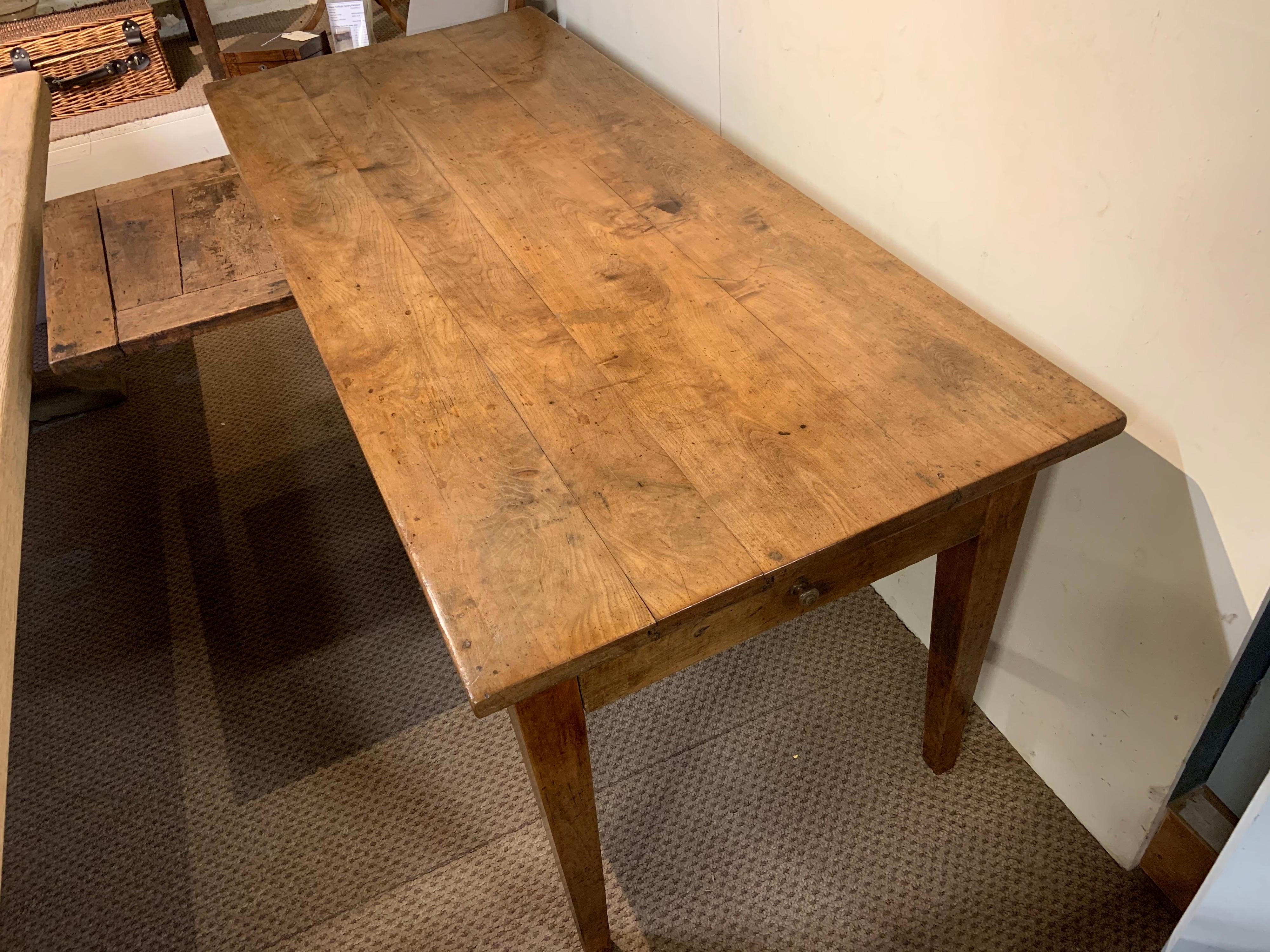 19th century pale cherry with gorgeous four plank top. The table sits on sturdy tapered legs, with one drawer on the end. The table has a great side bread slide. The gorgeous-looking table stands really well with excellent proportions.
  