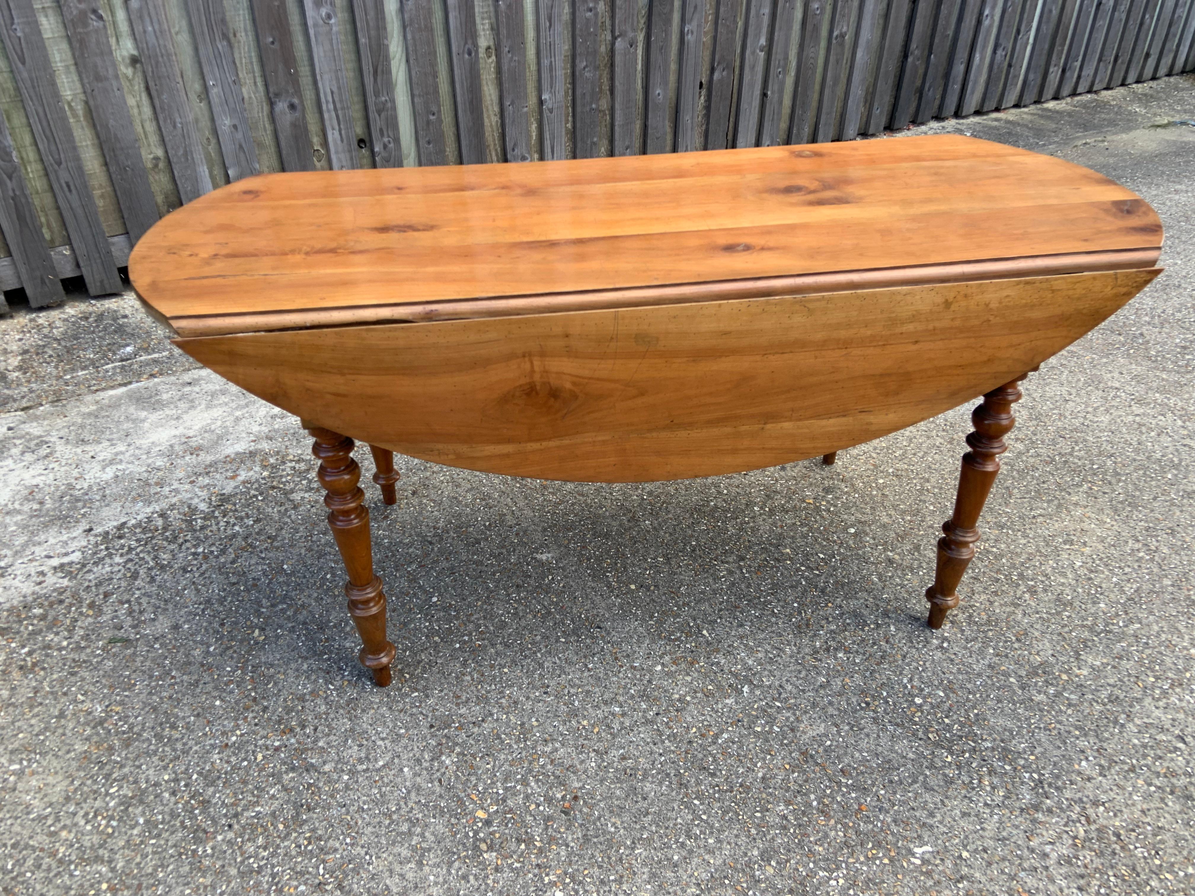 Table de salle à manger ovale en merisier ancien. Le centre de la table avec les feuilles abaissées mesure 25