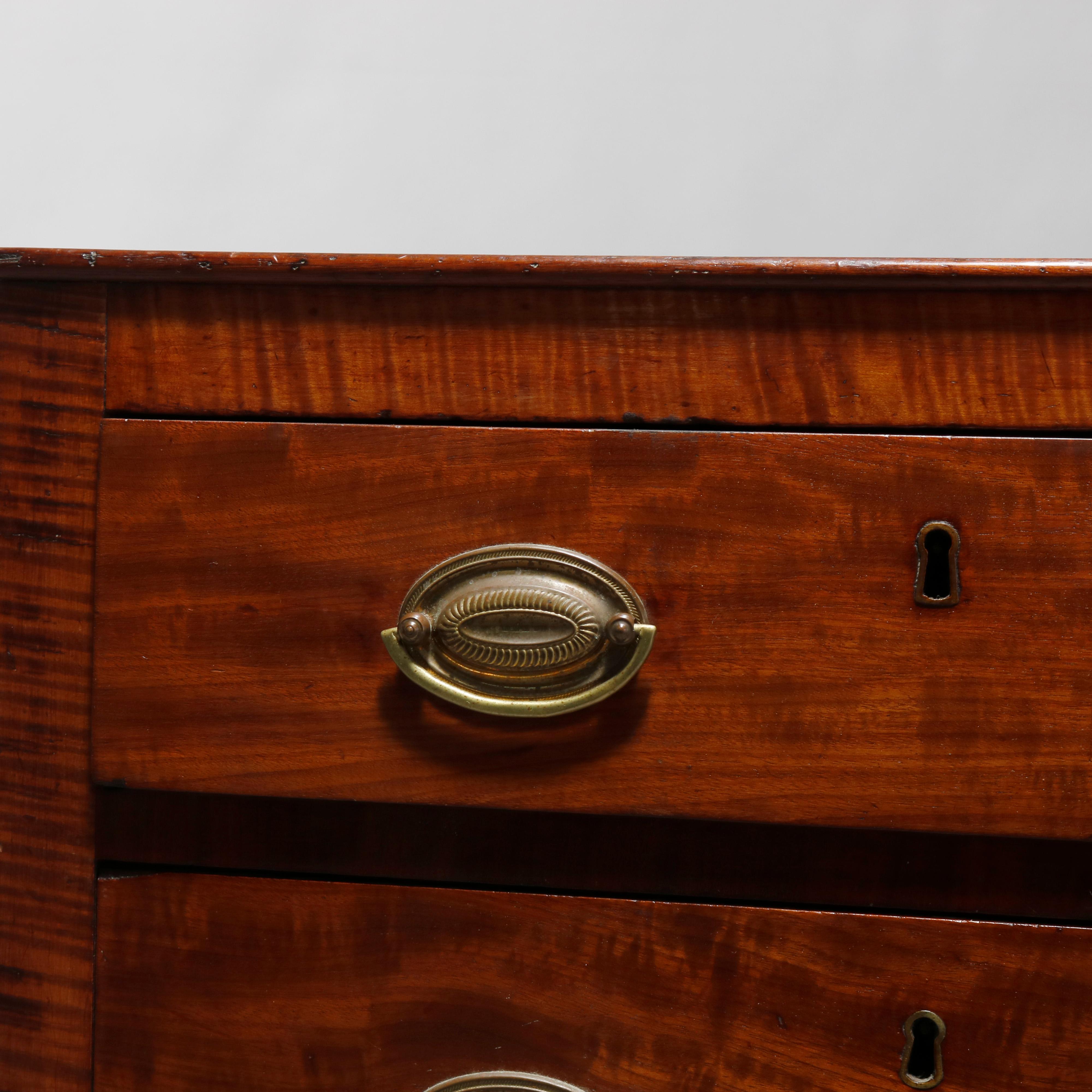 An antique Sheraton side stand offers cherry and tiger maple construction with case having two drawers with cast bronze pulls and escutcheons, raised on turned and tapered legs with casters, c1830

Measures: 30.25