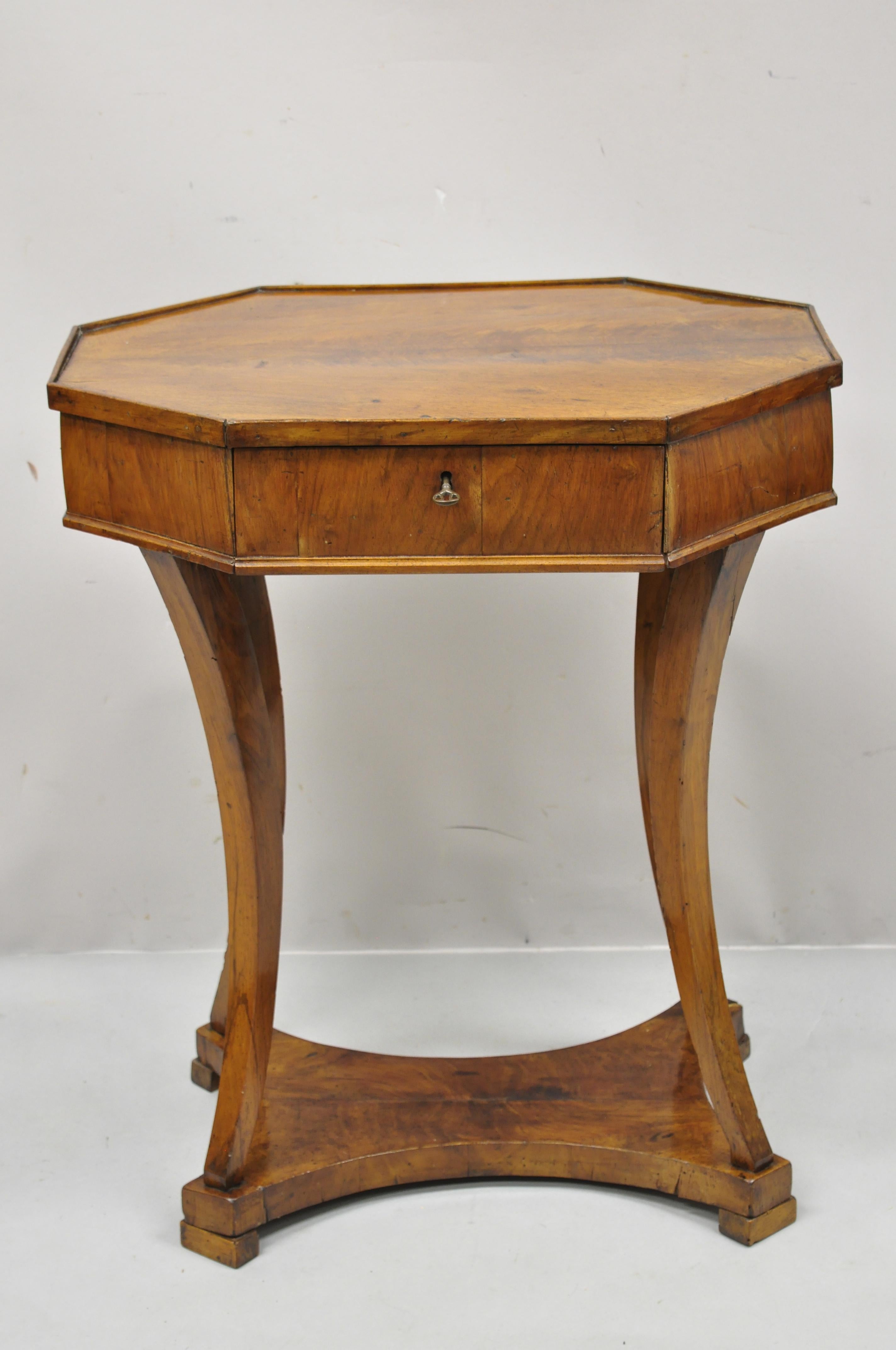 19th century antique cherry wood Italian Biedermeier one drawer accent lamp side table. Item features lower shelf, beautiful wood grain, working lock and key, 1 dovetailed drawer, shapley saber legs, very nice vintage item, quality Italian