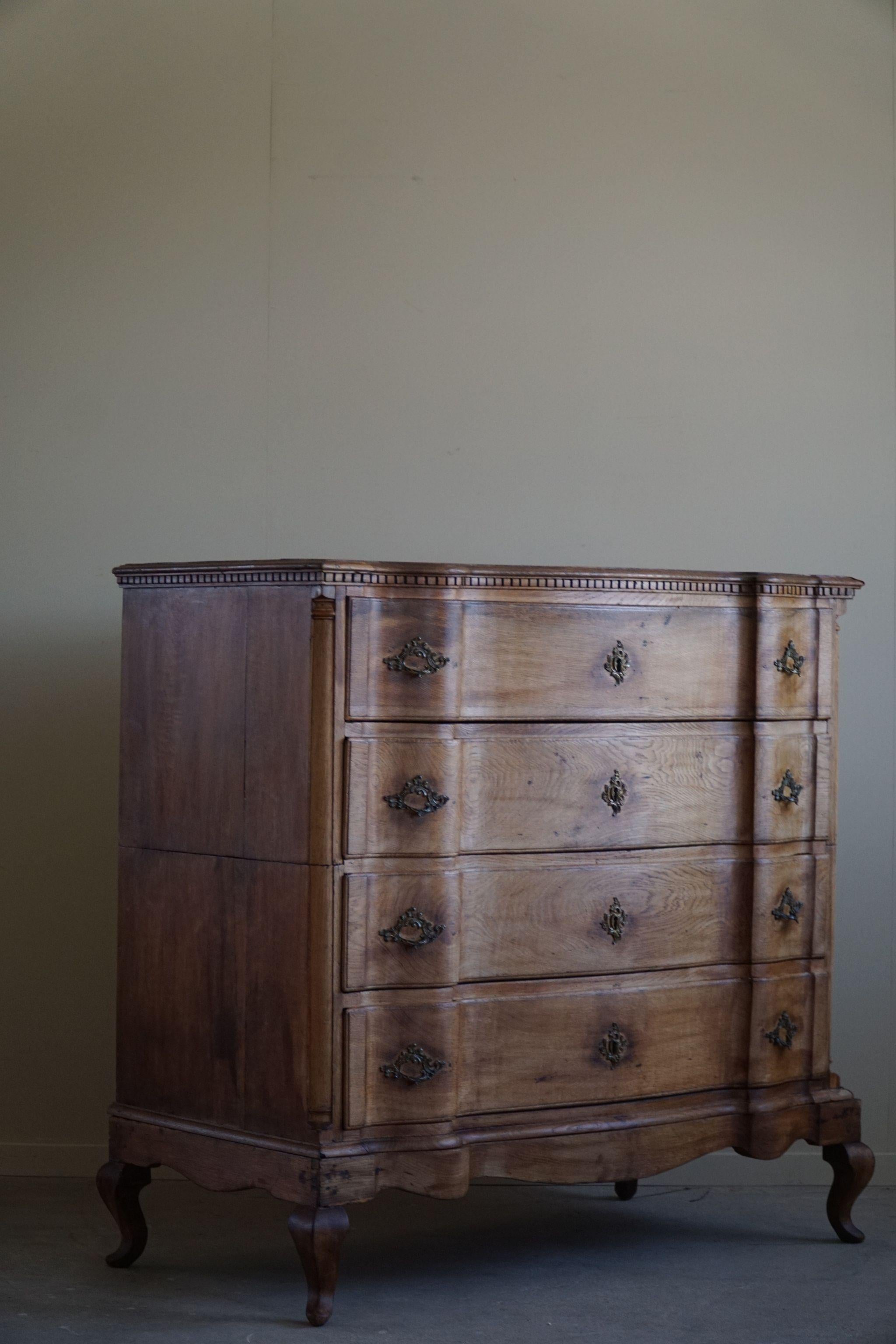 Romantic antique commode / chest of drawers, made by a Danish cabinetmaker in 1790-1810.. Louis XVI. This chest features great curves and carving skills and undoubtedly high quality. Made in solid oak with brass handles.

This beautiful chest of