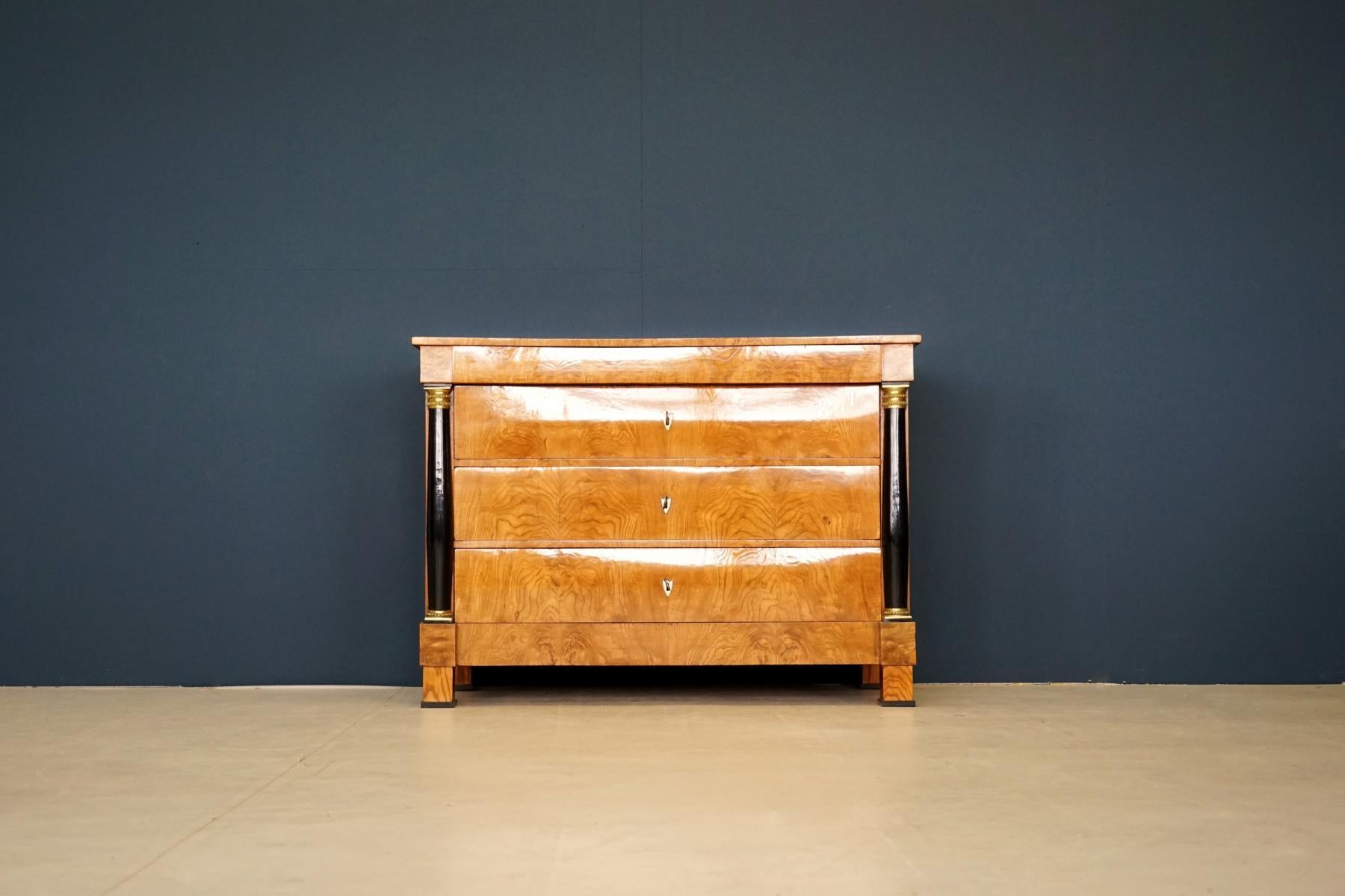 Antique chest of drawers, circa 1815. German Biedermeier. Ash on solid softwood corpus. Restored.
Antique chest of drawers with three large drawers and a narrow head drawer.
Ash veneered on solid softwood body, with gilded capitals. Extremely rare