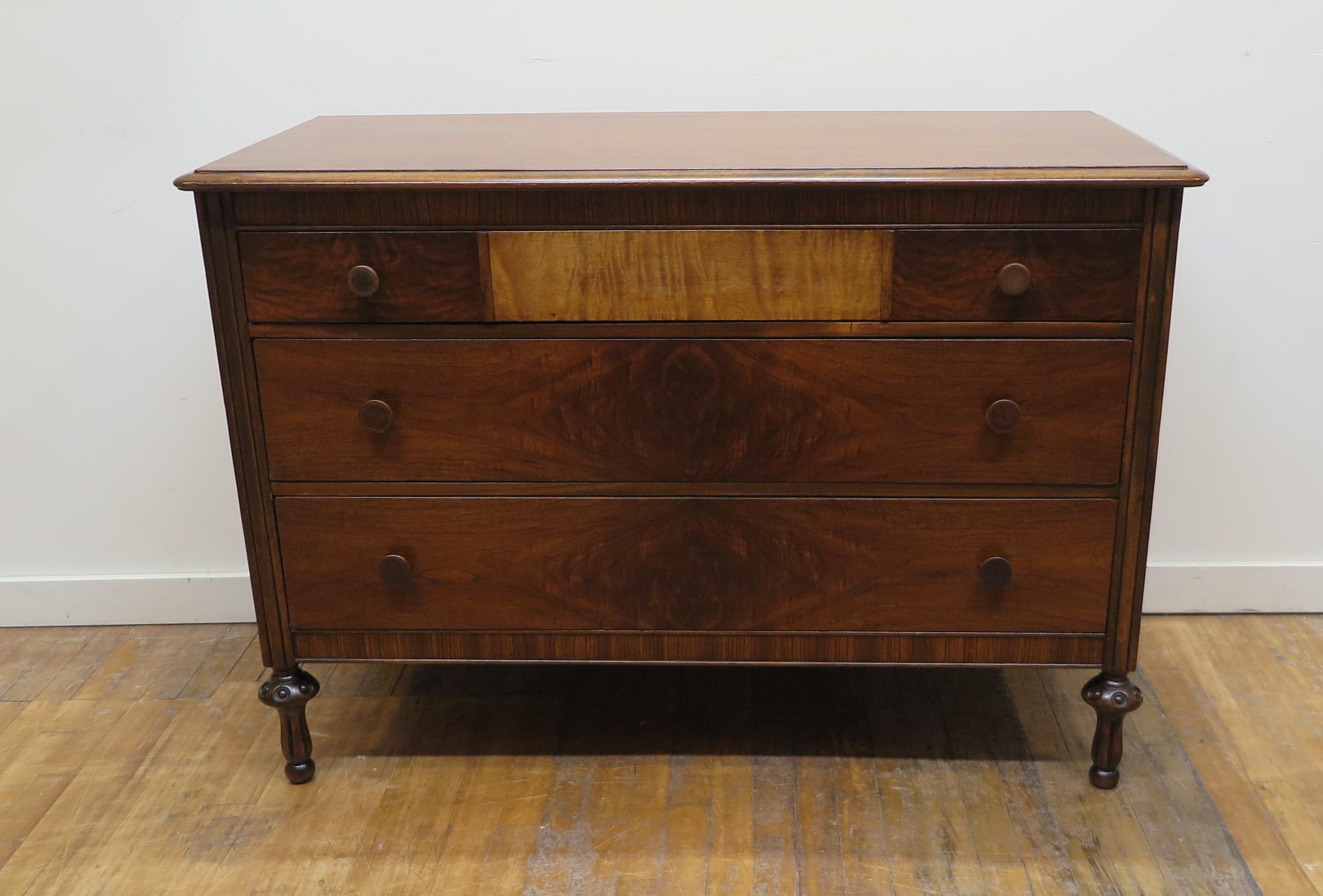 Interesting antique vintage chest of drawers dresser. Mahogany top with first drawer having a Tigger Maple center Plate, and lower drawers with matched Walnut Burl. In good refinished condition. American Colonial style with raised turned legs to the