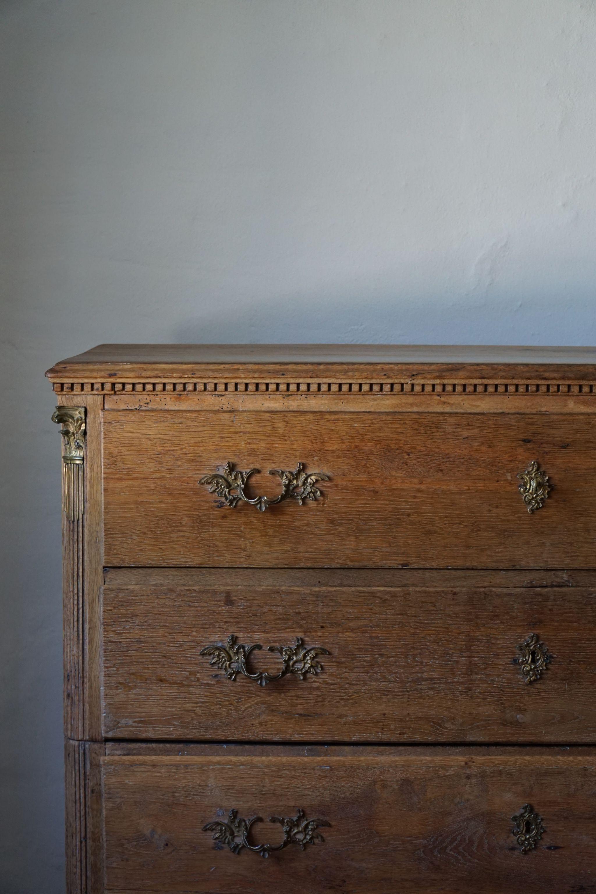 This beautiful Danish chest of drawers with brass handles has delightful carvings, adding a romantic touch to the solid oak. It is built in 2 sections, which makes it easier to move around. Made in mid-19th century.

The overall impression is